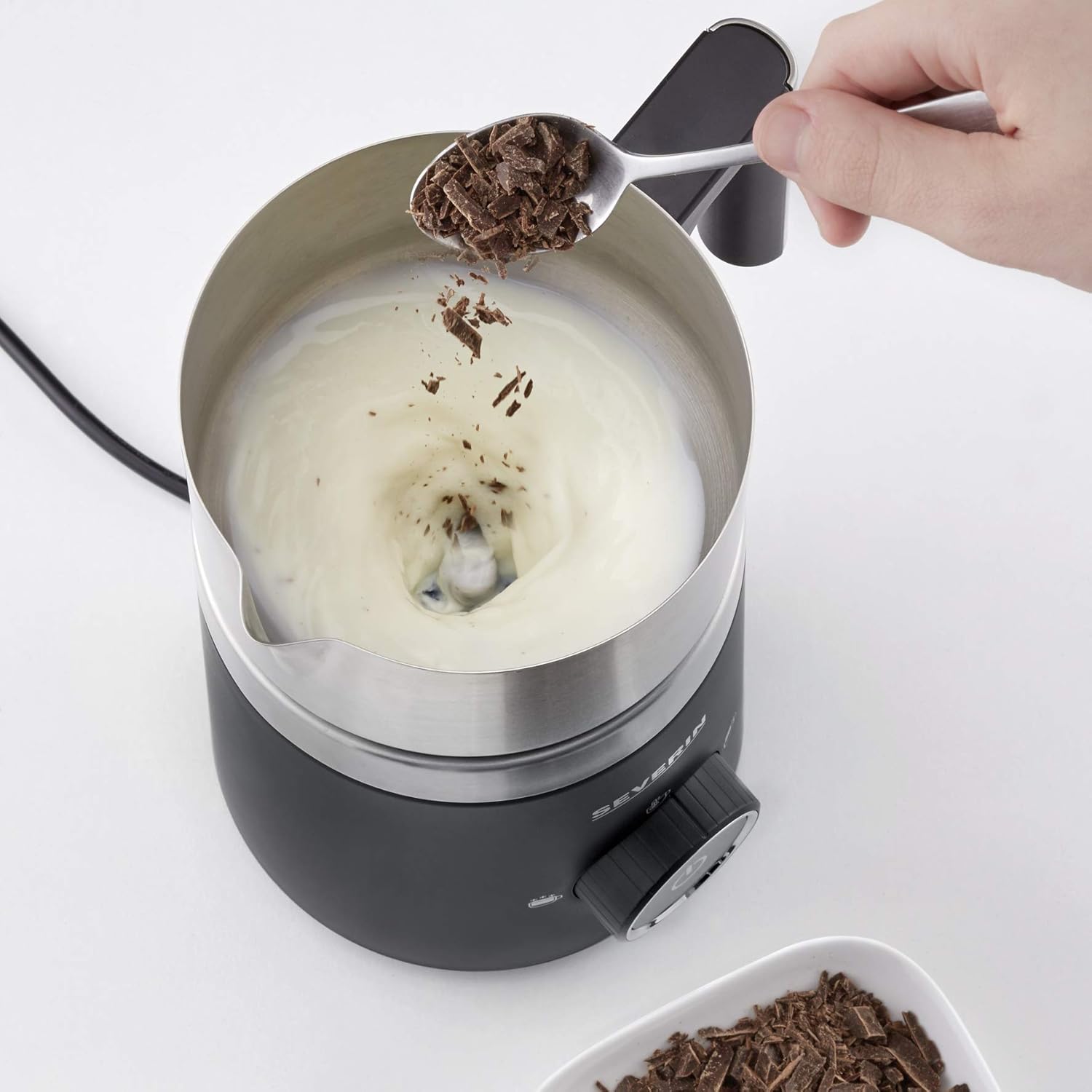 Adding chocolate shavings to milk in the frother jug