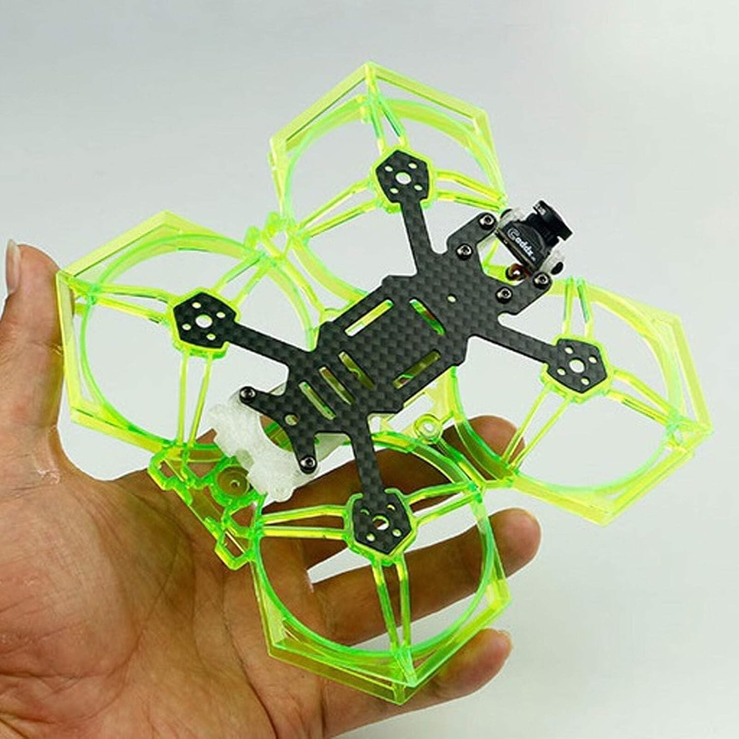 A hand holding the LDARC FF2 93mm FPV Racing Drone Frame Kit, showcasing its carbon fiber frame and neon green propeller guards.