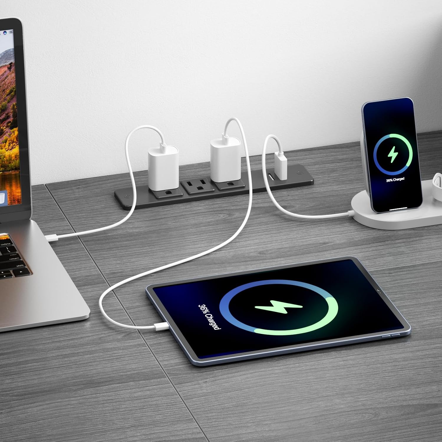 Close-up of the integrated power outlet on the Korfile desk, showing devices charging via AC, USB, and Type-C ports.