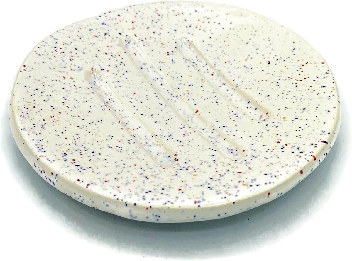 A small handmade ceramic soap dish with white speckled glaze