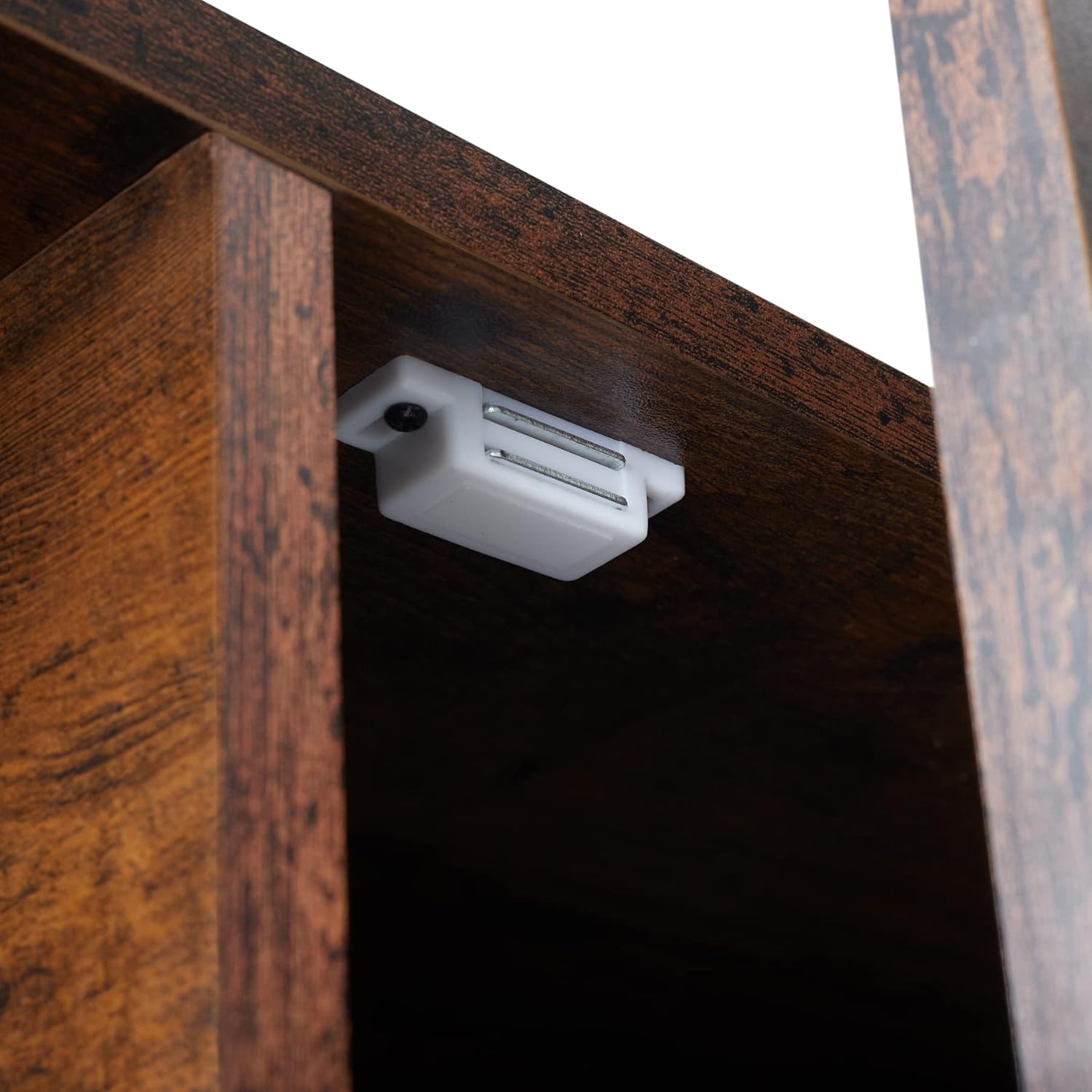 Close-up of the magnetic catch installed inside the TV stand's door compartment.