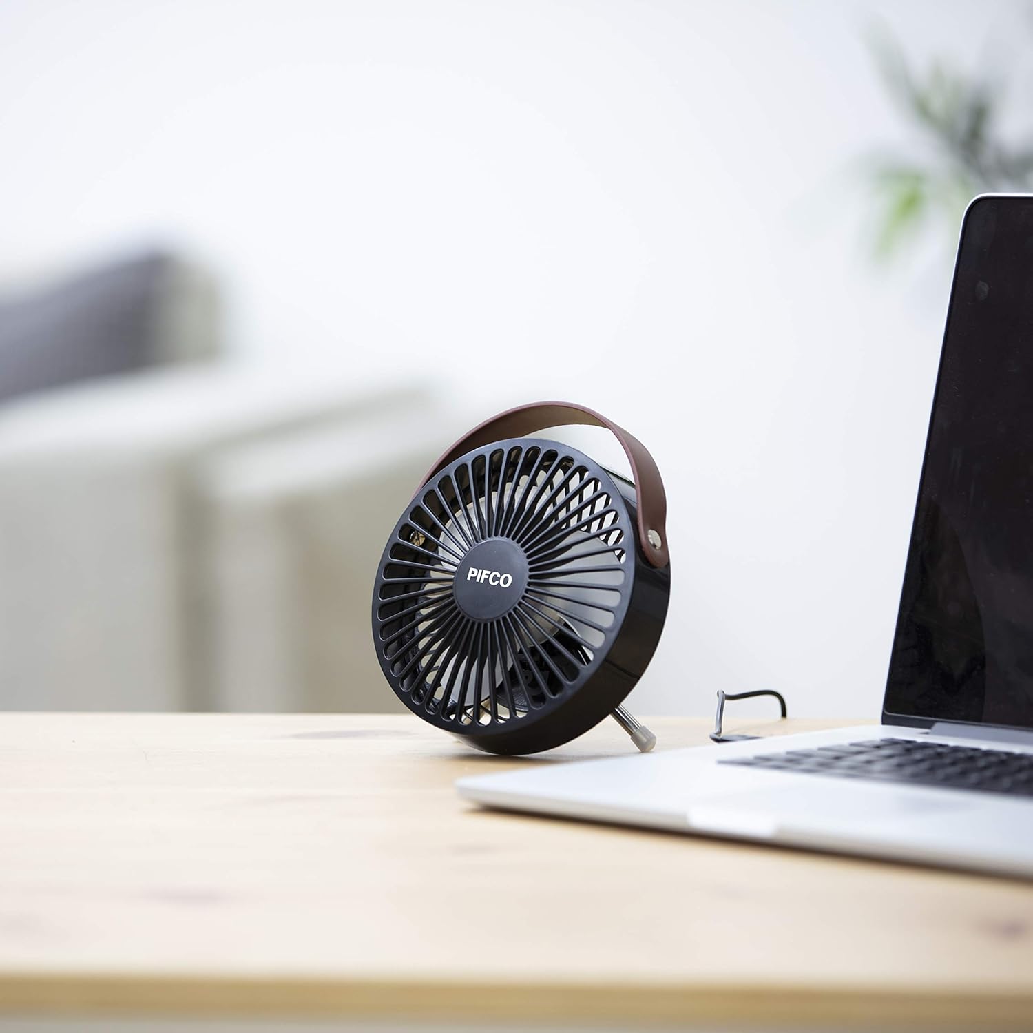 Pifco Mini USB Desk Fan placed on a wooden desk next to a laptop