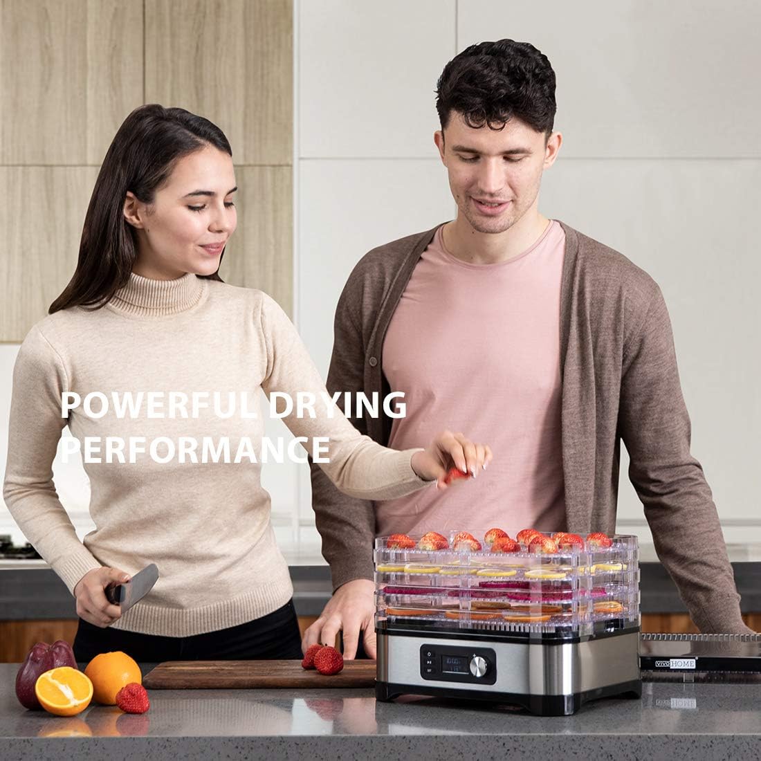Two people preparing food for dehydration, with sliced strawberries on a tray of the VIVOHOME Food Dehydrator.