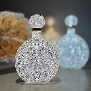 زجاجة عطر من زجاج كريستال شفاف بتصميم كلاسيكي أنيق بنقشة زخرفية محفورة وشكل دائري مع لمسات ذهبية أنيقة