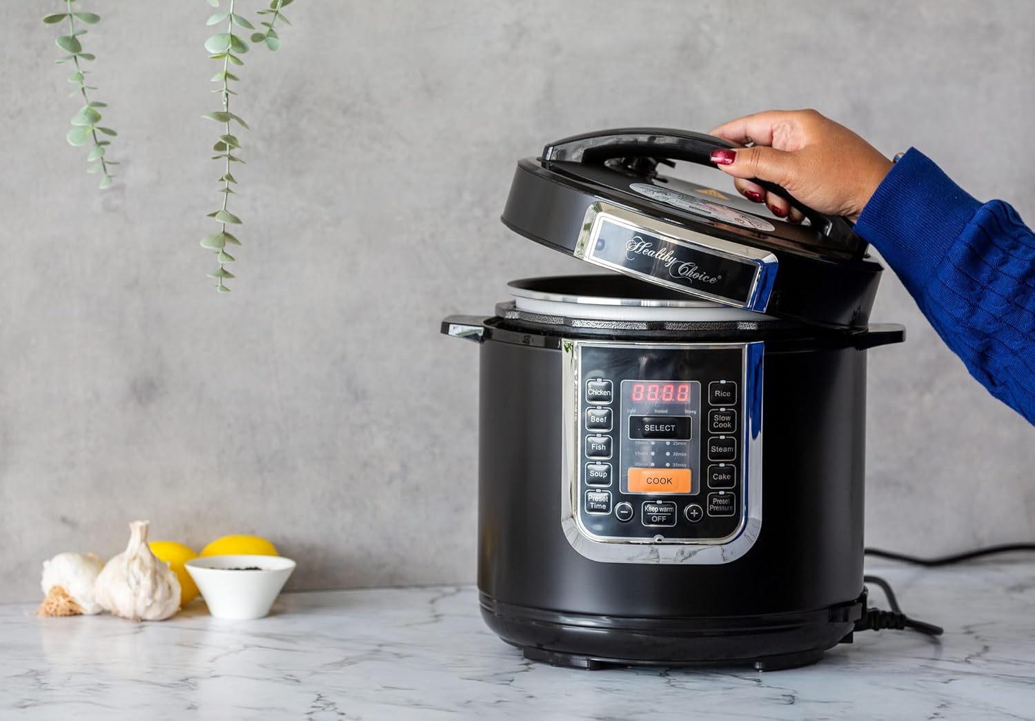 Hand opening the lid of the Healthy Choice 6L Digital Pressure Cooker