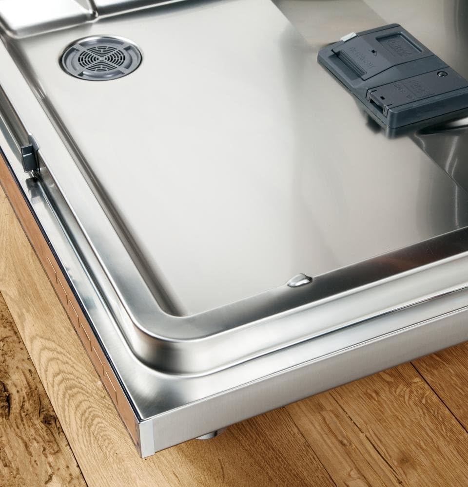 Interior base of the dishwasher showing the stainless steel tub and filter