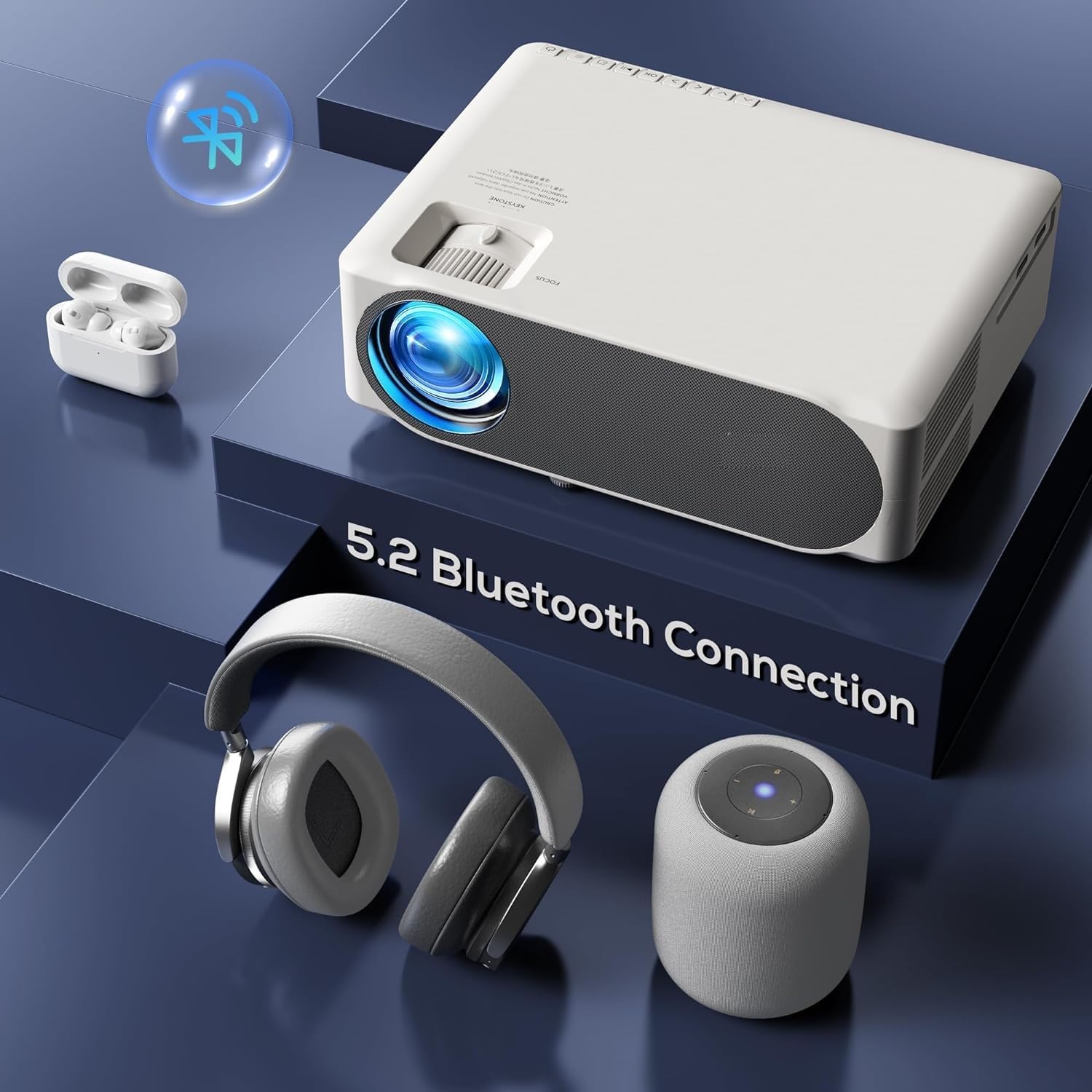 AUN AKEY6S Projector with Bluetooth headphones, earbuds, and a speaker, indicating 5.2 Bluetooth connection capability.