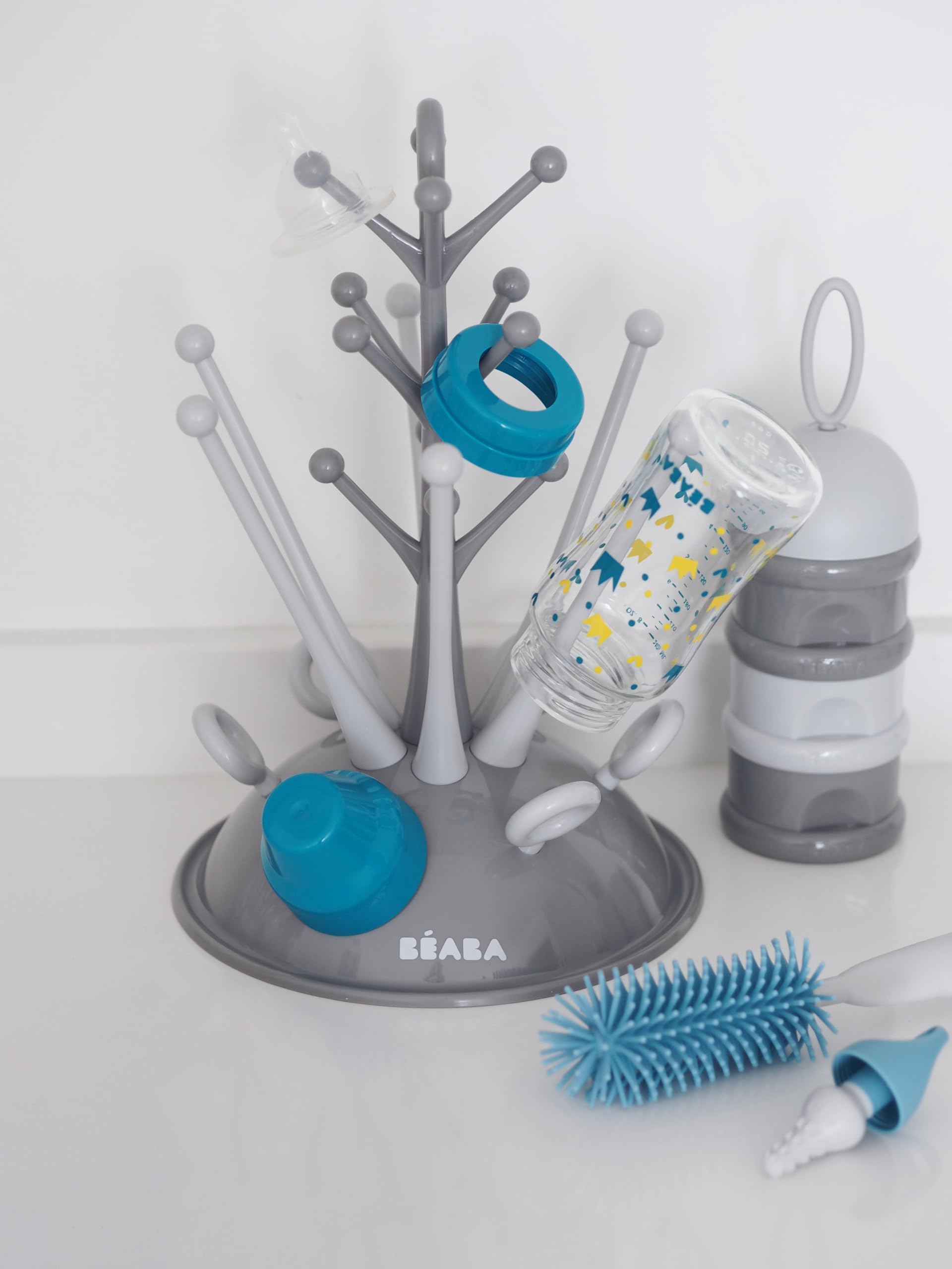 BÉABA - Set para Recién Nacido Unisex, Escurrebiberones forma de árbol Gran capacidad, Dosificador de Leche Apilable, Limpiabiberones de Silicona, Babero bebé 100% Algodón, Motivo Tropical