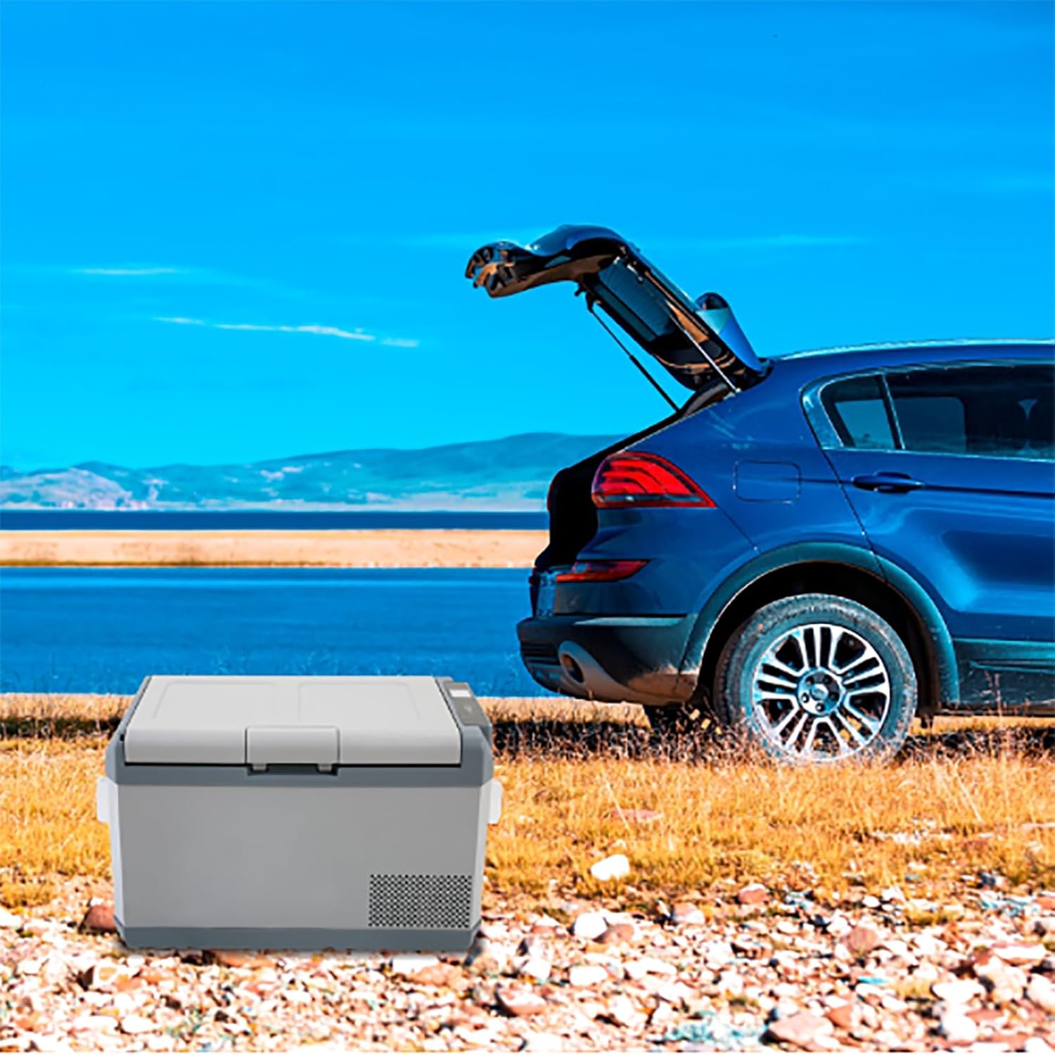 ERICAT 36 Liter Portable Car Refrigerator Freezer placed in the trunk of a car by a lake.