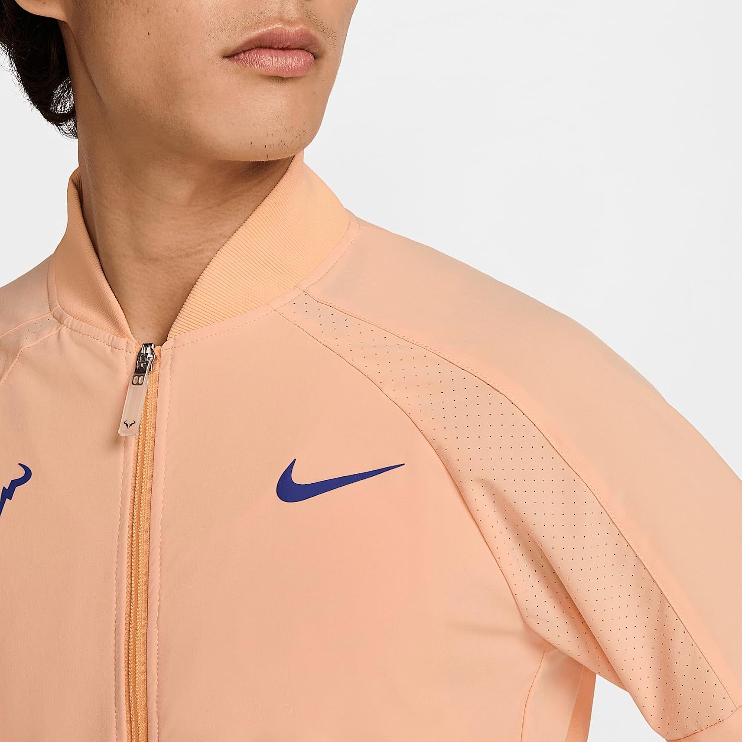 Close-up of the jacket's shoulder and chest area, showing the Nike swoosh logo and perforated fabric details.