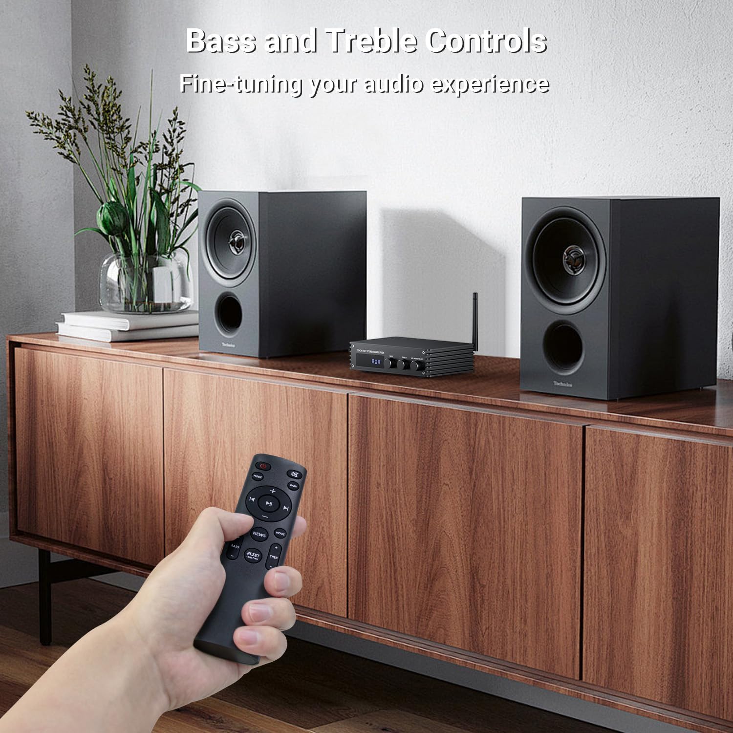 Hand holding remote control pointed at Inwa MZ633 amplifier with two speakers, illustrating bass and treble controls