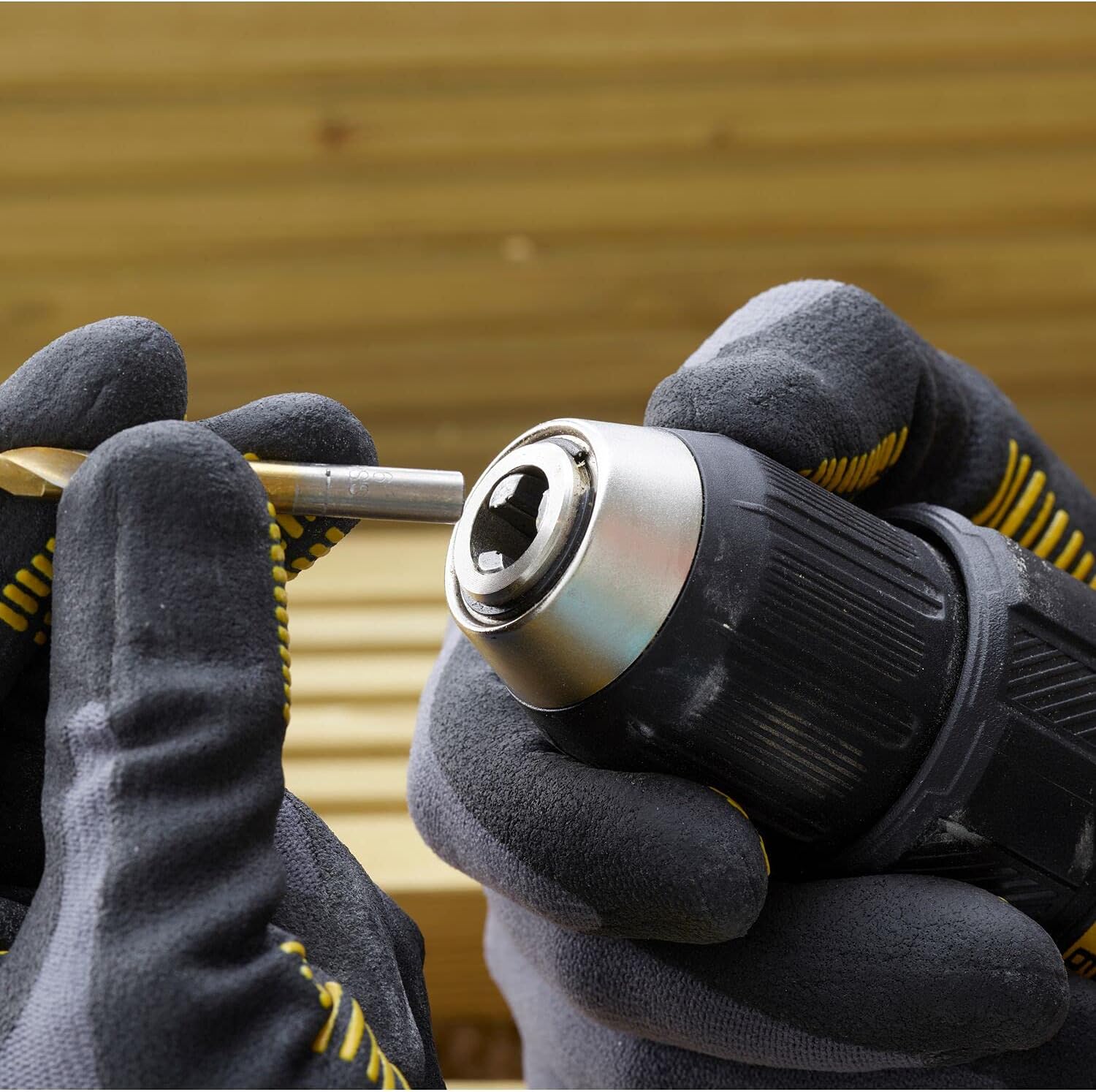 Hands inserting a drill bit into the keyless chuck of the STANLEY drill