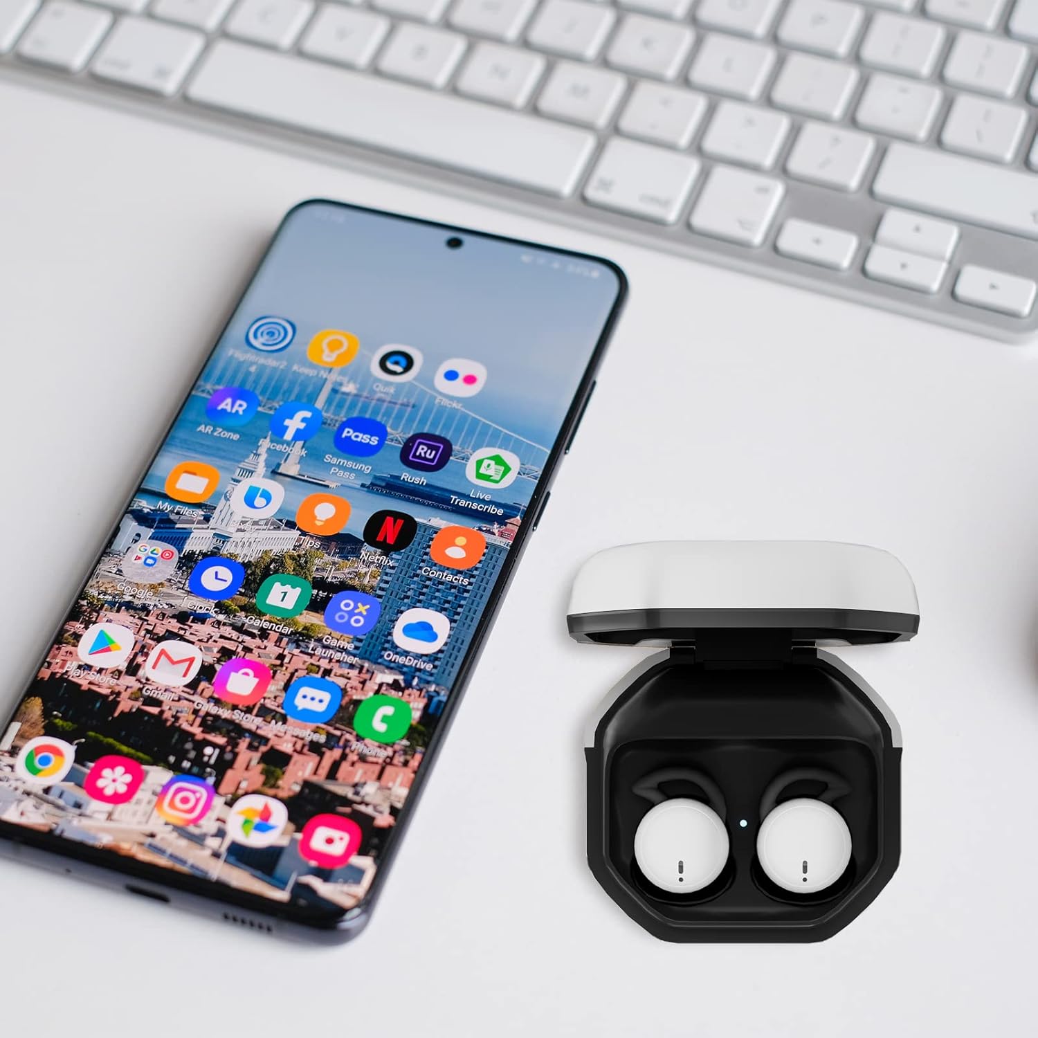 Smartphone displaying apps next to SQRMINI MY002 charging case with earbuds