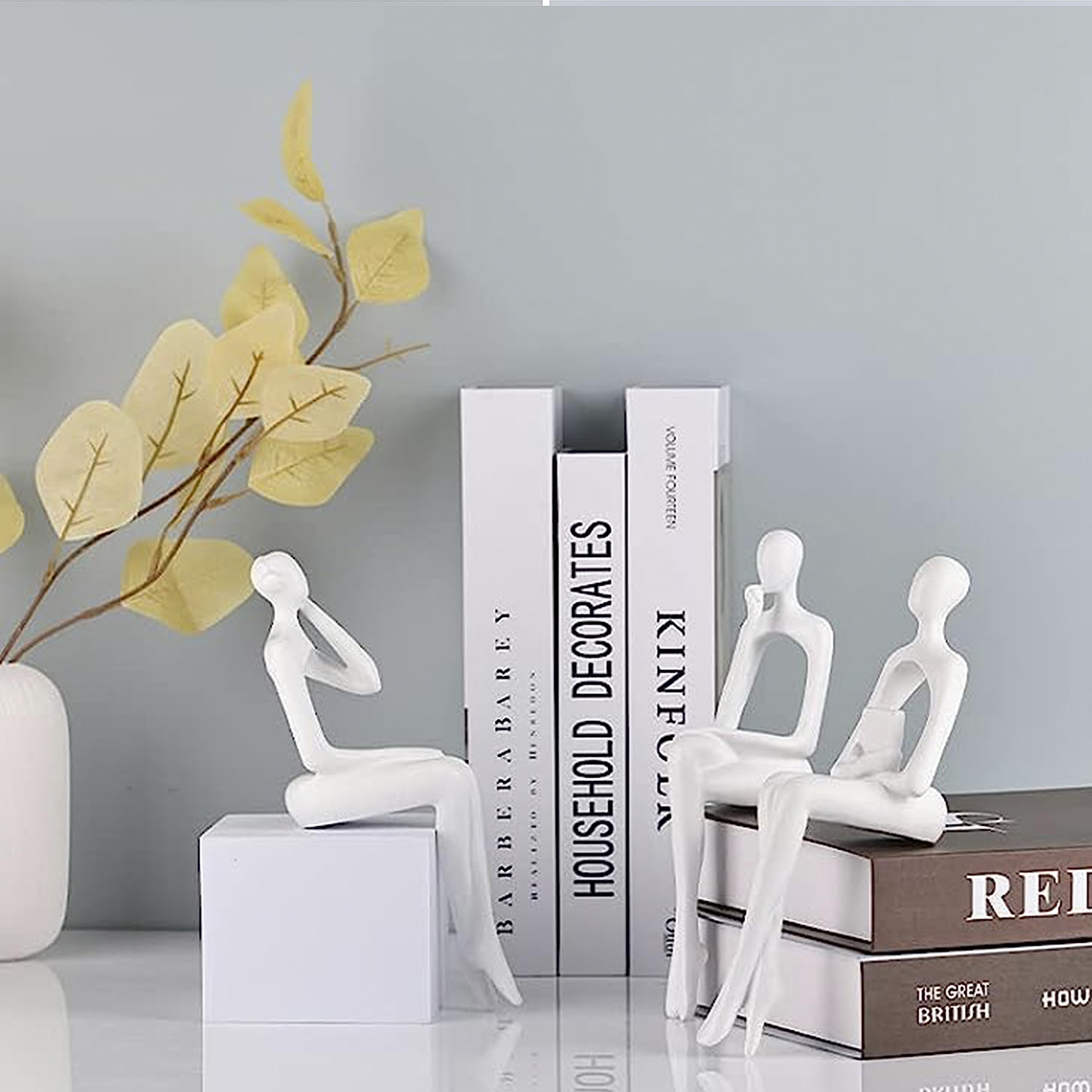 Statua seduta, una scultura astratta di una persona seduta su una libreria pensando