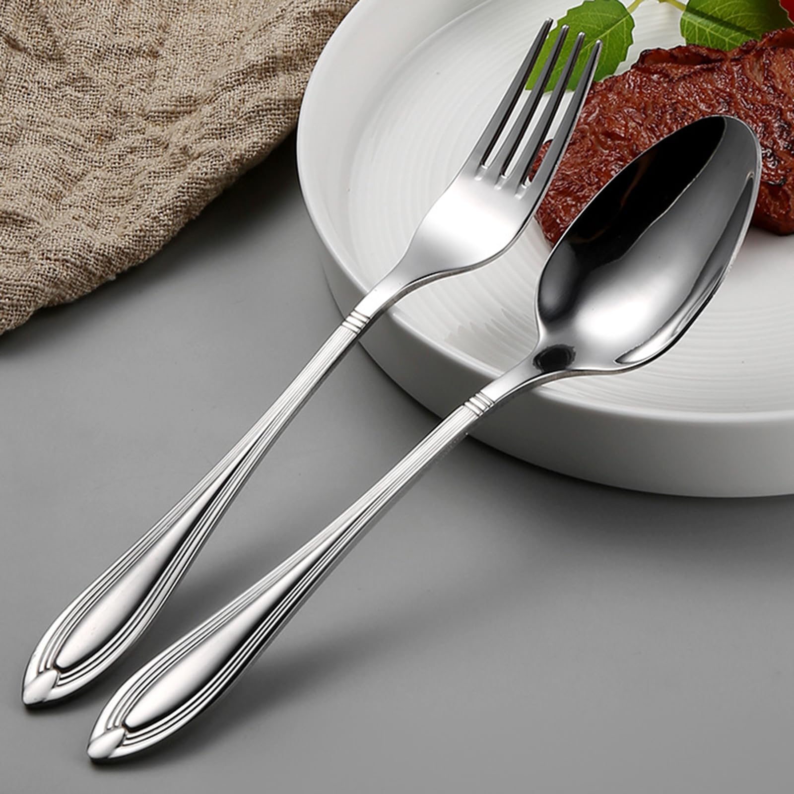 Ce Service de Couverts pour 16 Personnes Comprend Un Couteau de Table, Une Fourchette de Table, Une cuillère de Table et Un Couteau à Dessert. Il est doté d'un Manche raffiné et est fabriqué