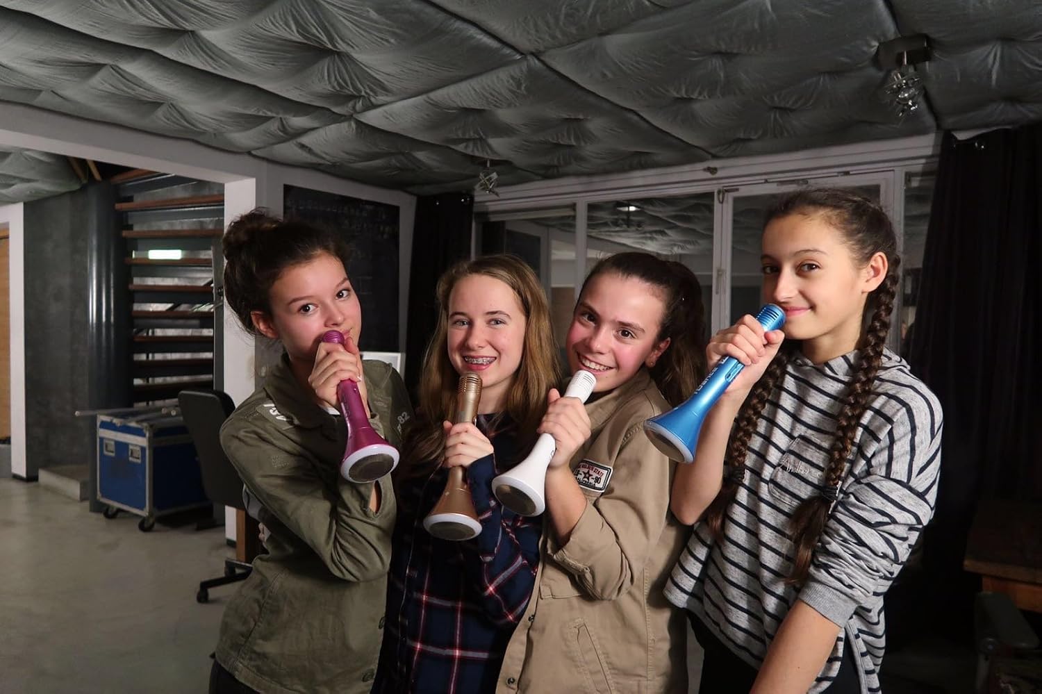 Group of four young girls holding iDance Party MIC PM 10 microphones in various colors