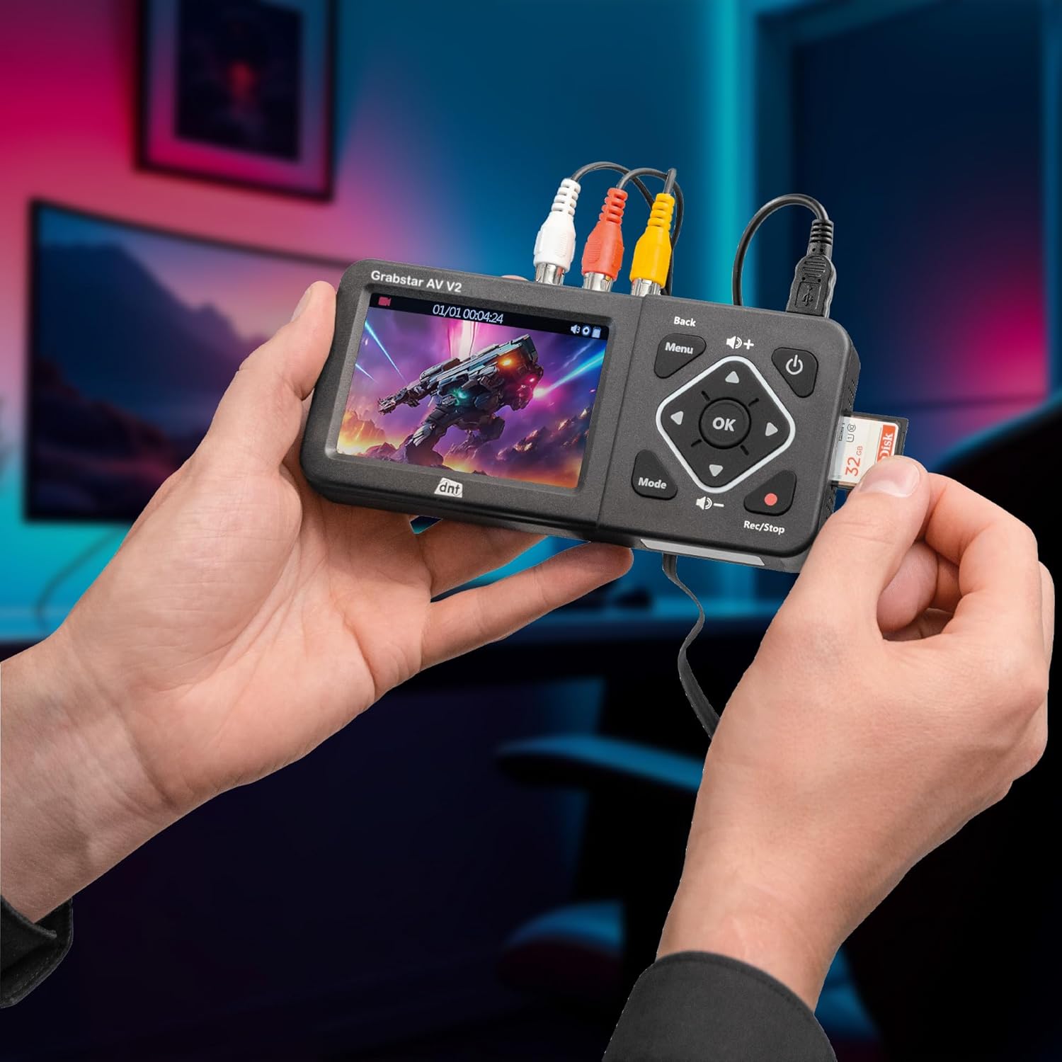 Hands holding the DNT Grabstar AV V2, demonstrating the insertion of an SD card into its slot.