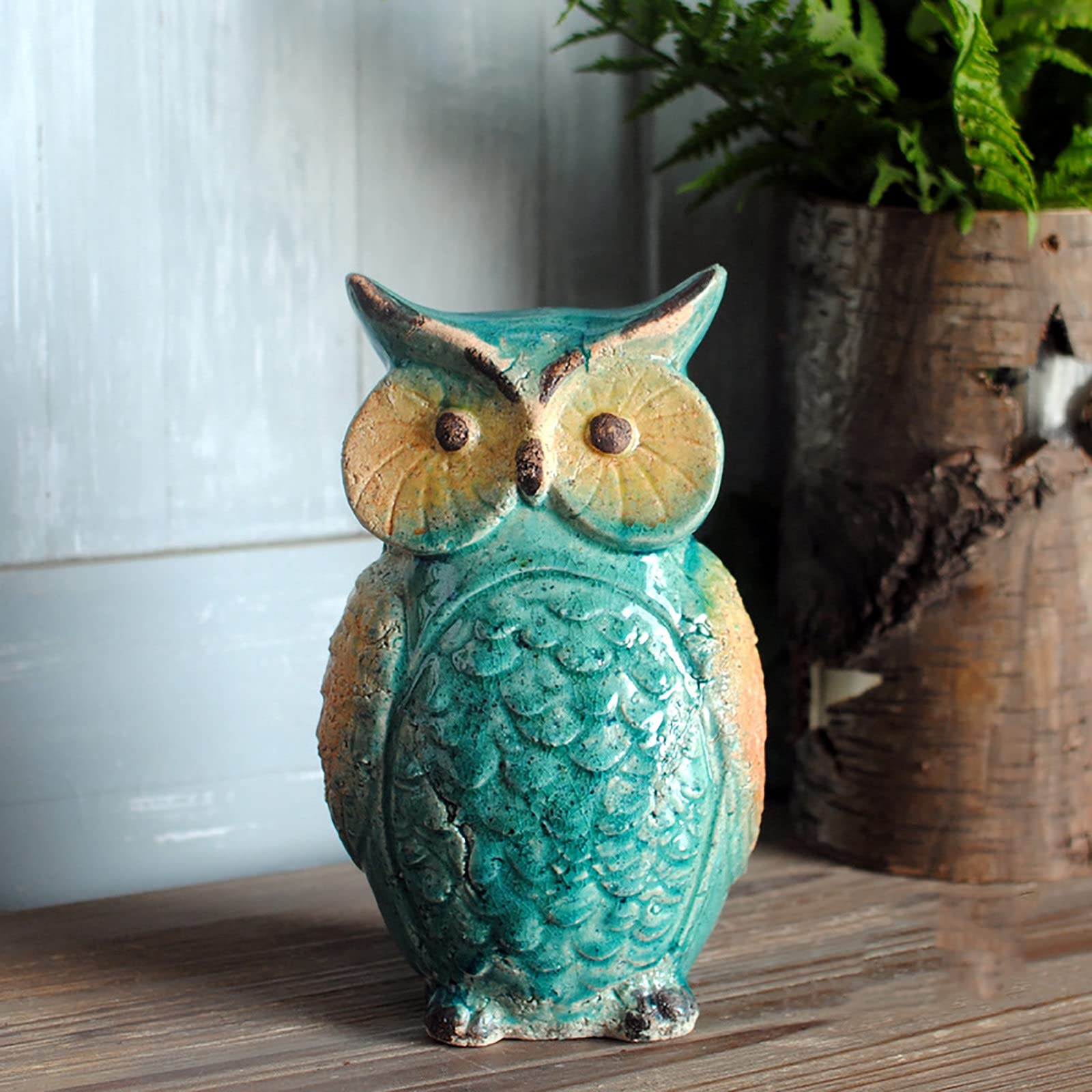 Statue hibou en céramique verte sur une étagère de salon ou dans un meuble de jardin