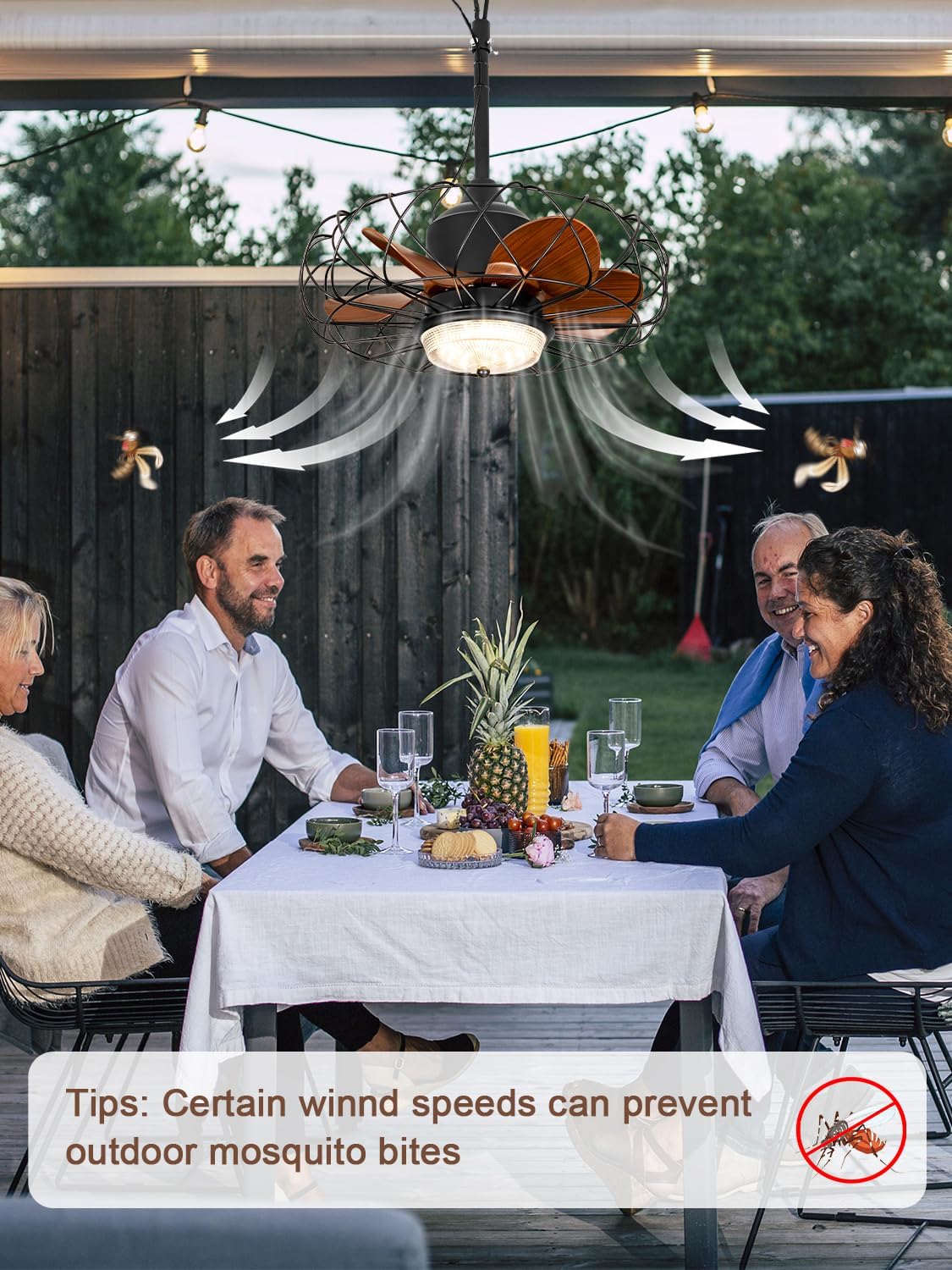 Outdoor fan operating above a group of people dining, with an arrow indicating airflow and a note about mosquito deterrence.