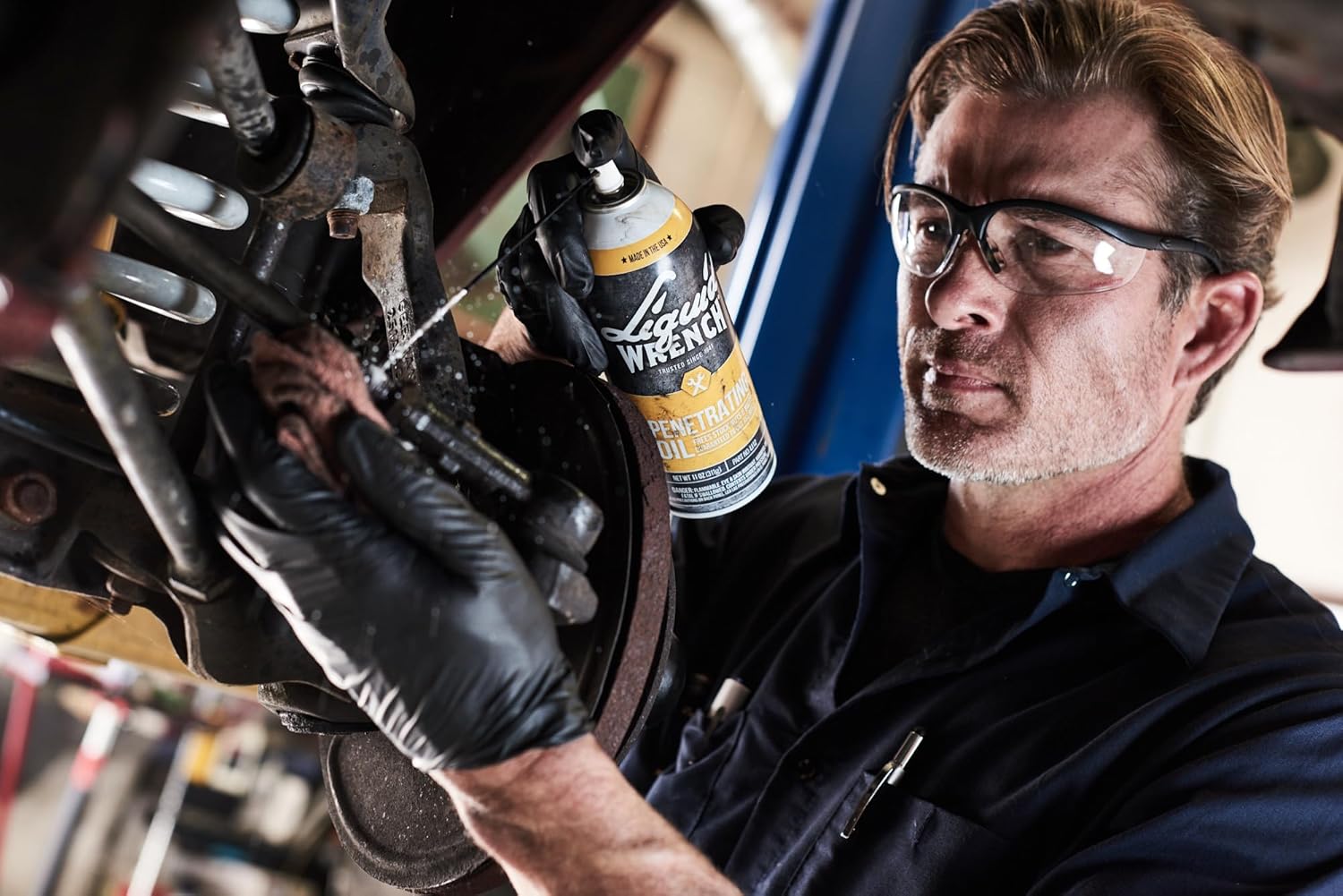 Person applying Liquid Wrench Penetrating Oil to a car part
