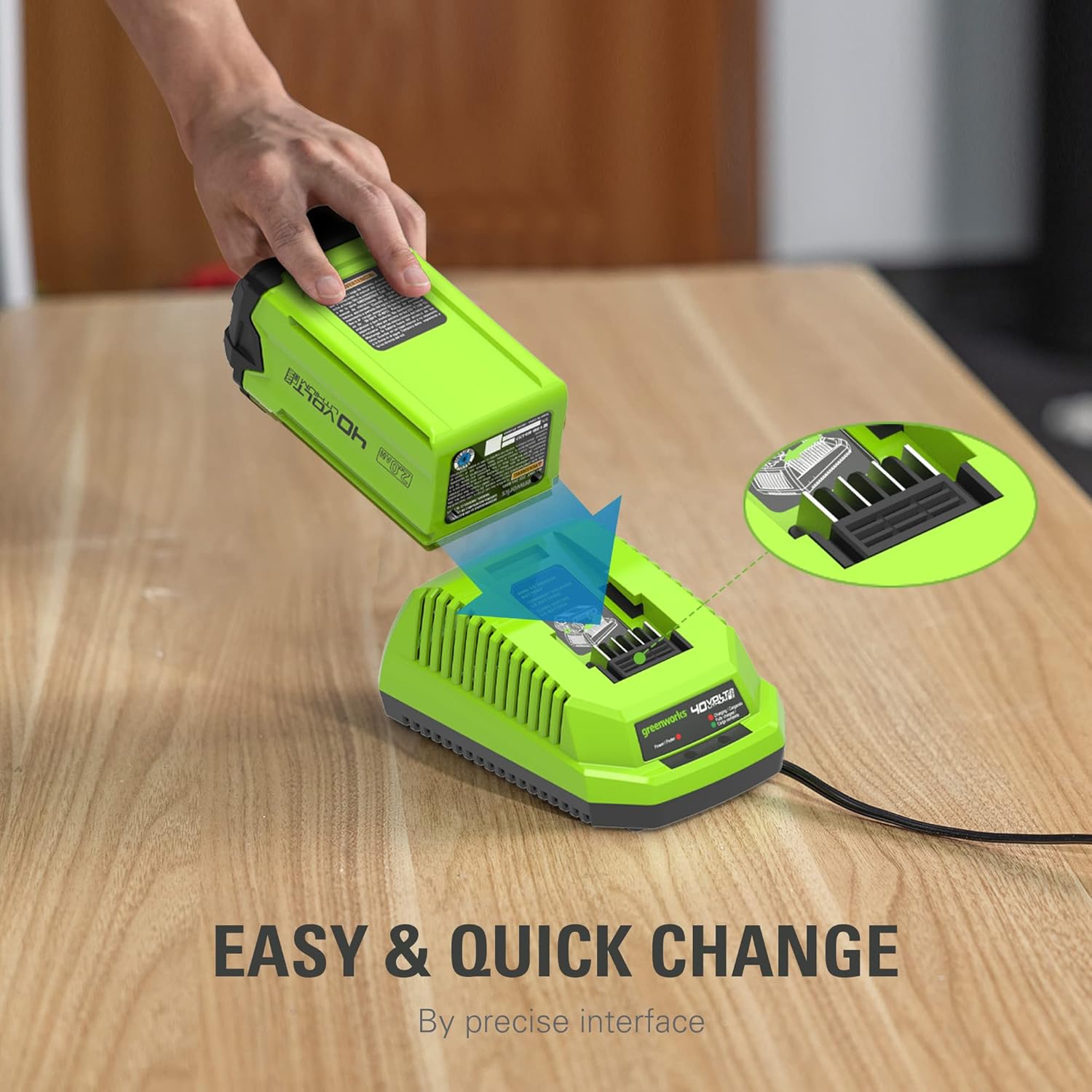 A hand inserting a Greenworks 40V battery into the charger.