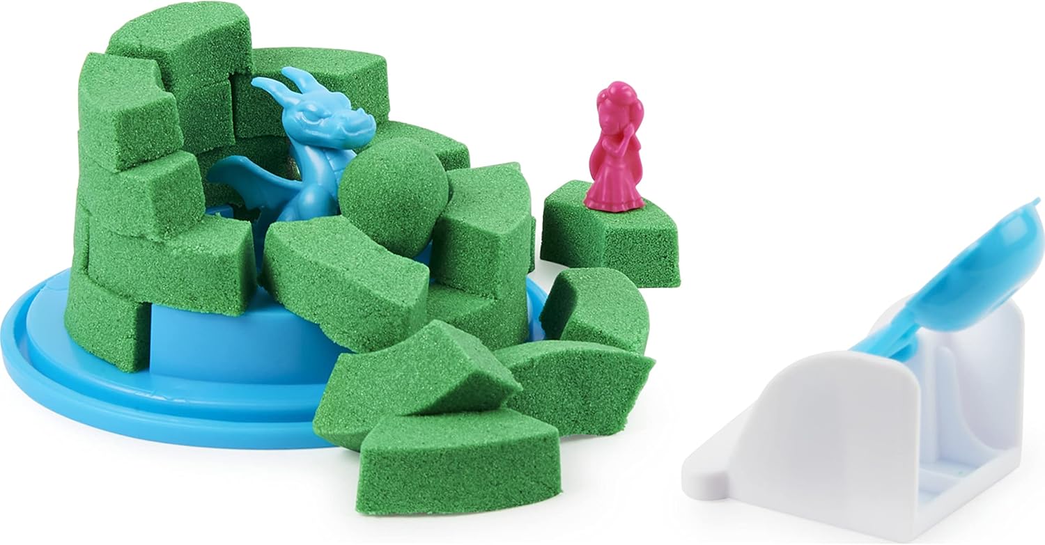 Green Kinetic Sand molded into a dragon and castle pieces, with small pink and blue figures.