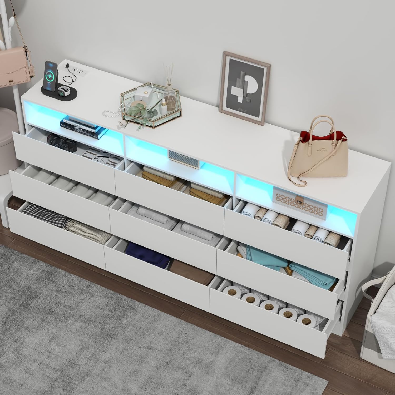 Top-down view of open dresser drawers filled with various folded clothes and items