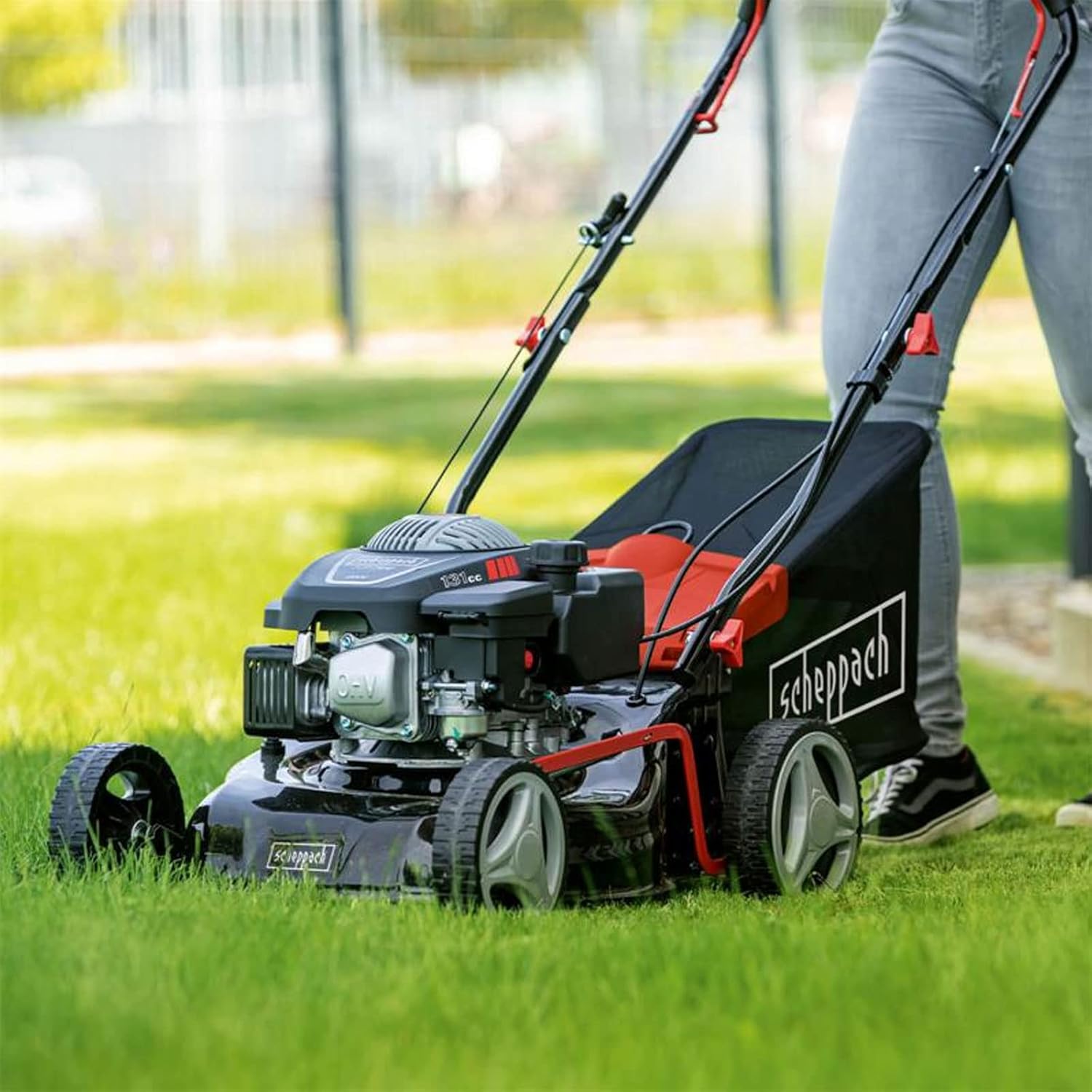 Person operating Scheppach RM420 lawnmower on a green lawn
