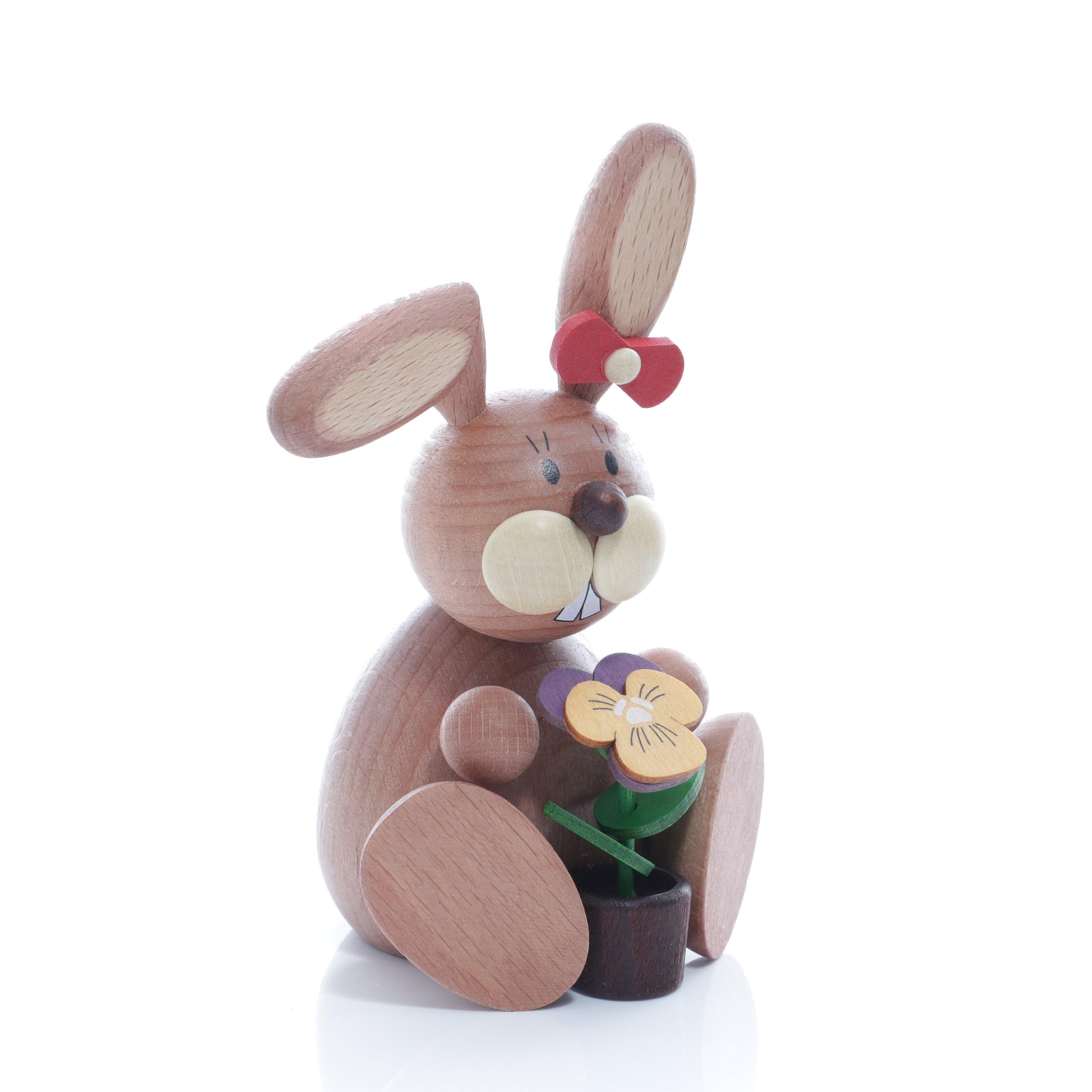 Lapin de Pâques assis ornés de pensées pour créer un centre de table printanier