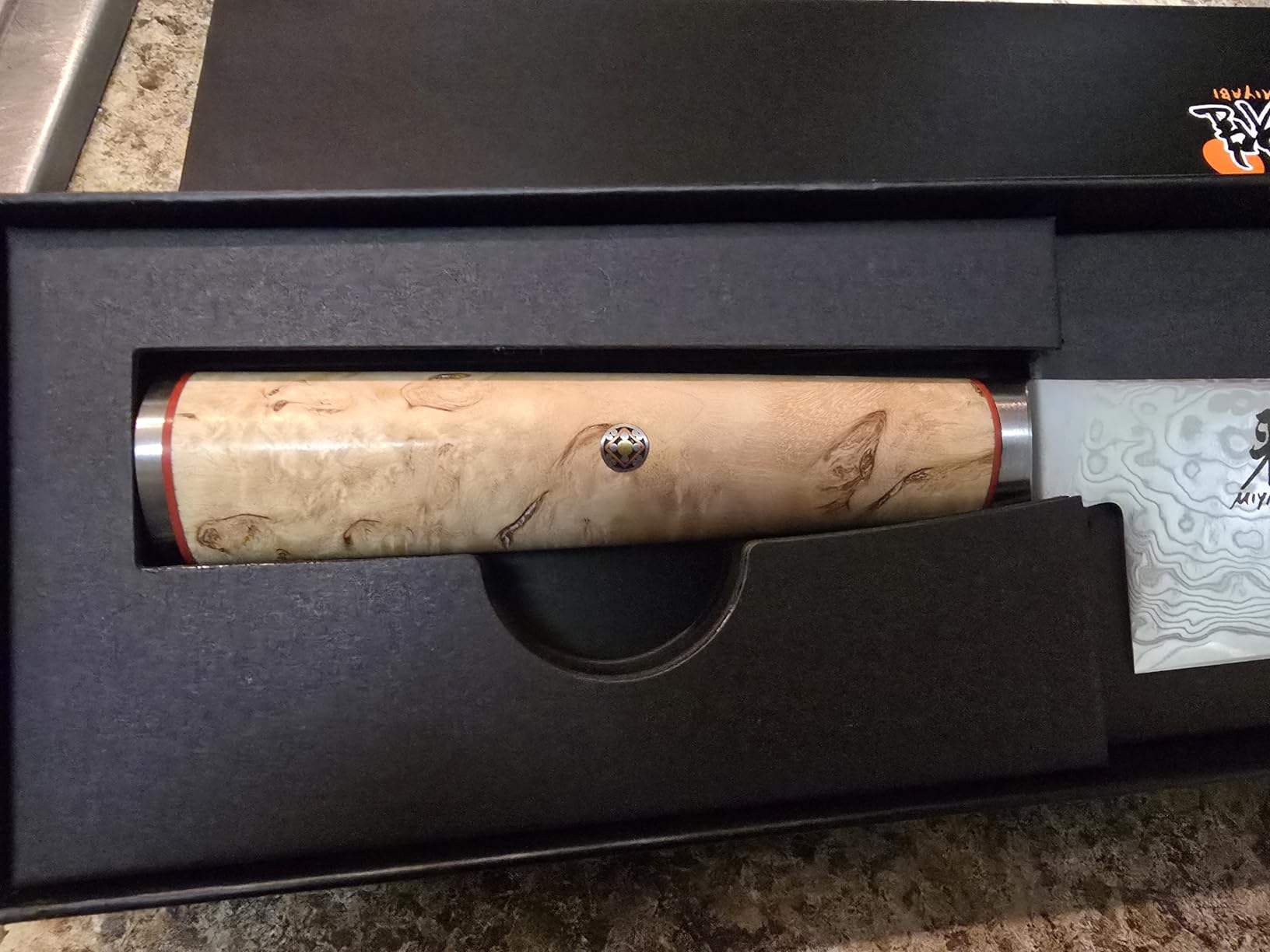 Close up of the Miyabi Birchwood chef knife blade edge and damascus pattern