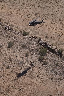 Posterazzi UH-60 Black Hawk hovers above U.S. Marines as they prepare to extract a simulated casualty Poster Print by hoist during exercise Angel Thunder 2013, (11 x 17)