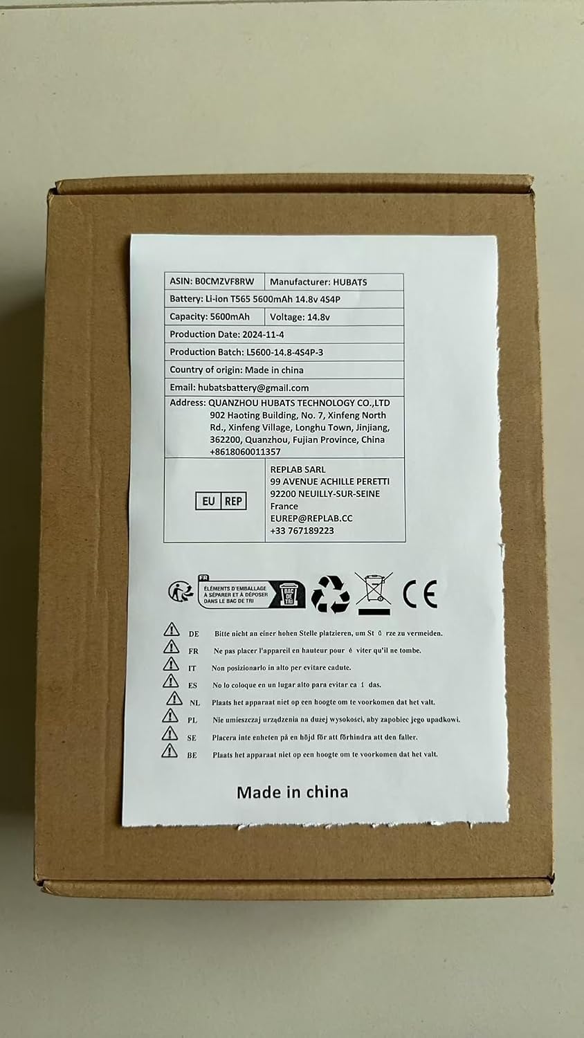 Product packaging label for Tuklye T565 battery, showing specifications like ASIN, Battery type, Capacity, Voltage, Production Date, Manufacturer, and contact information.
