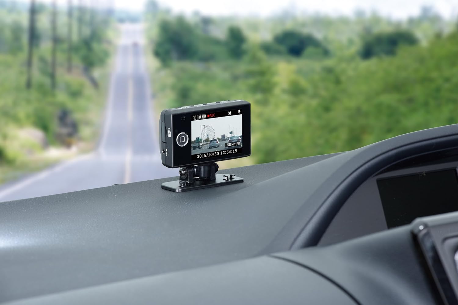 COMTEC HDR-251GH Drive Recorder mounted on a car dashboard, front view with road ahead.