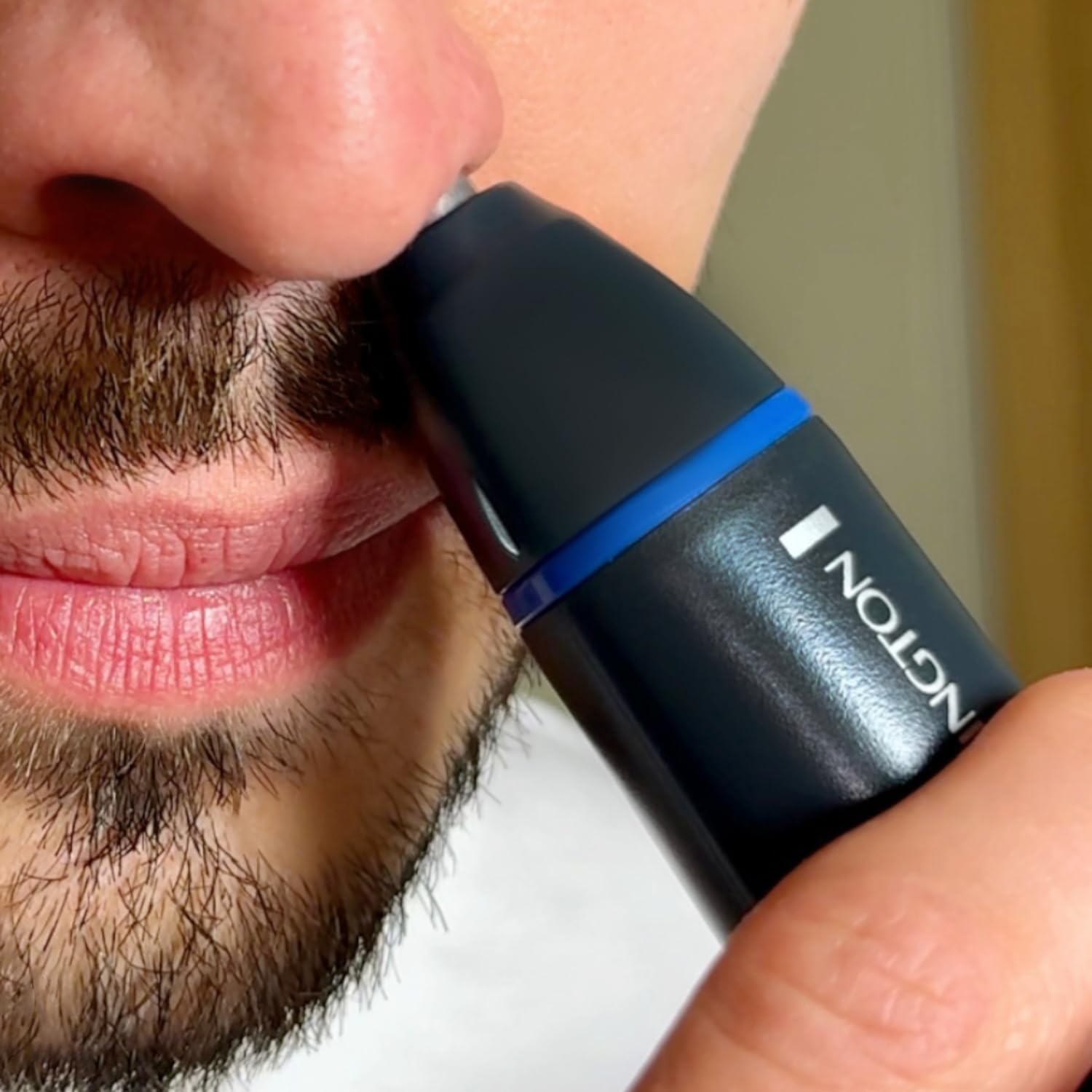 Close-up of a person using the Remington NE3850 trimmer to trim ear hair