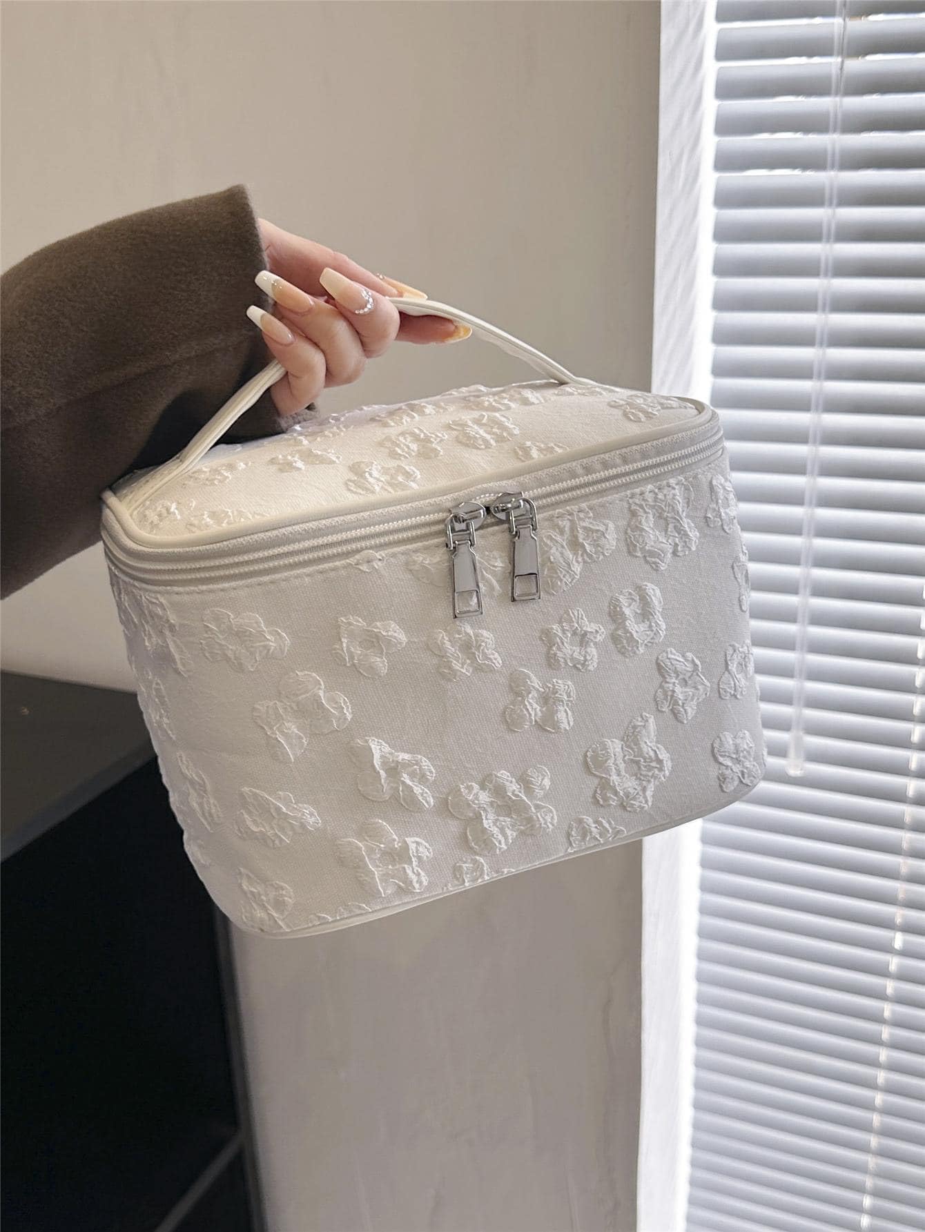 Cosmetic bag with floral pattern, featuring a top flap and enclosed sides, ideal for storing cosmetics, Blanco, trumpet