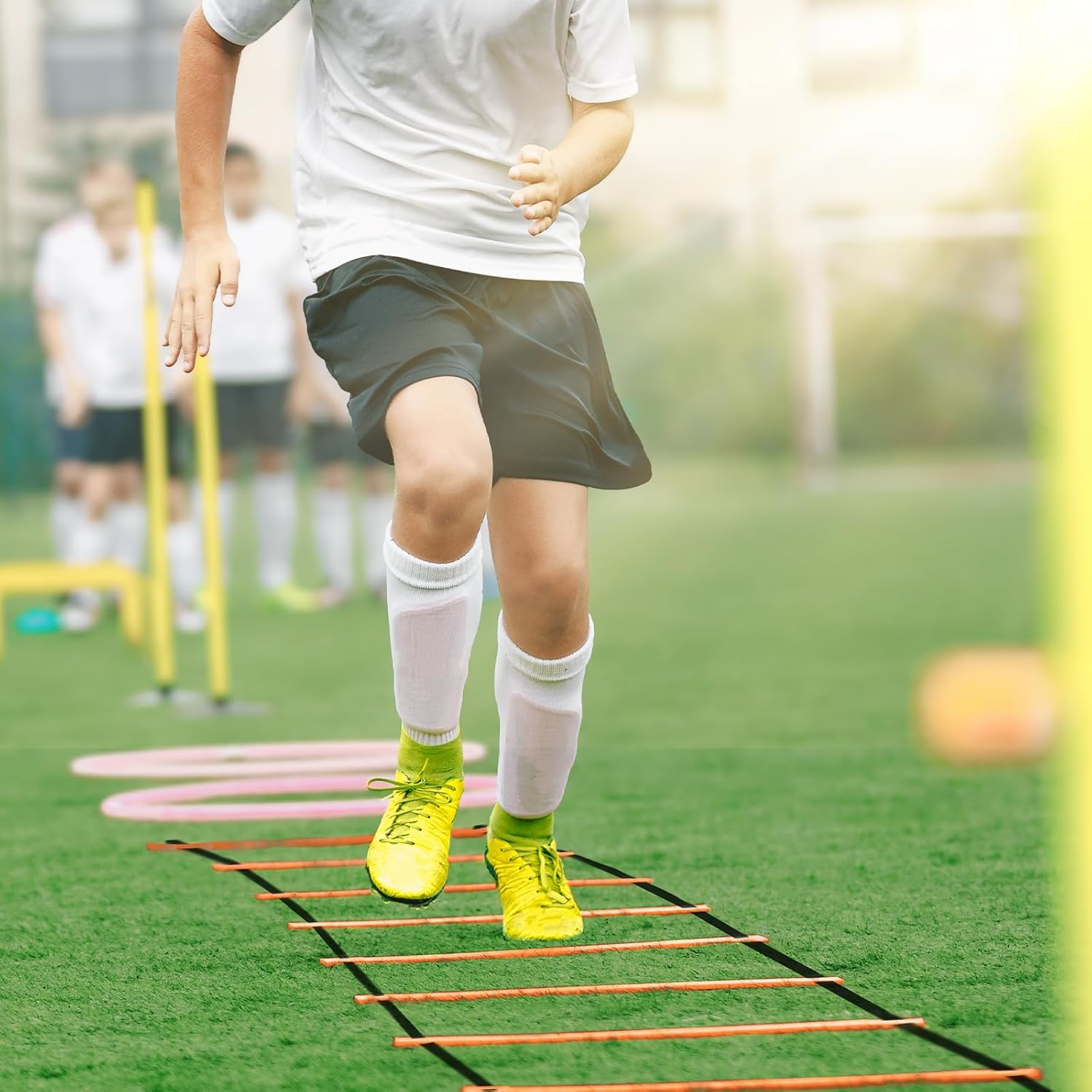 Child running through an agility ladder on a green field