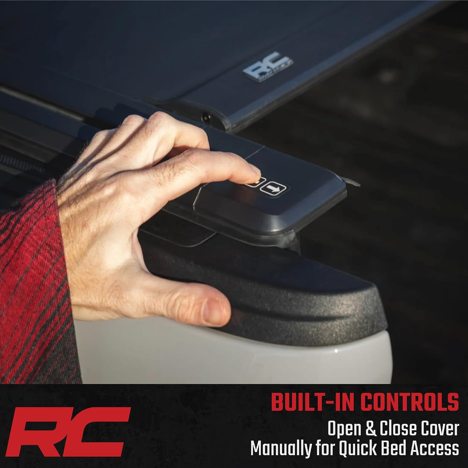 Hand pressing buttons on the built-in control panel of the tonneau cover rail.
