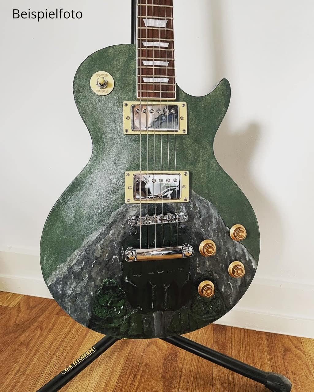 Example of a finished custom electric guitar with a green and grey mountain landscape paint design