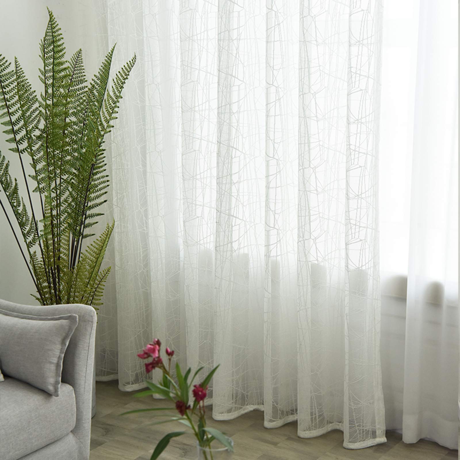 Rideau tulle brodé fleurs blanches pour illuminer le salon de votre villa