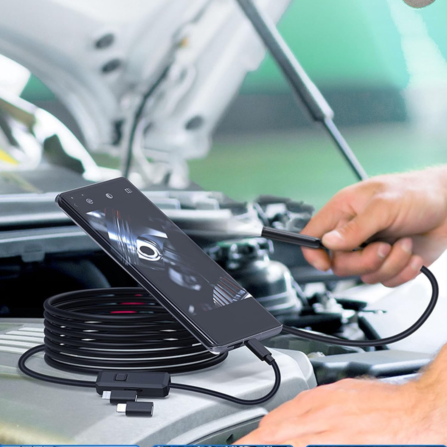 Endoscope camera connected to a smartphone, inspecting a car engine
