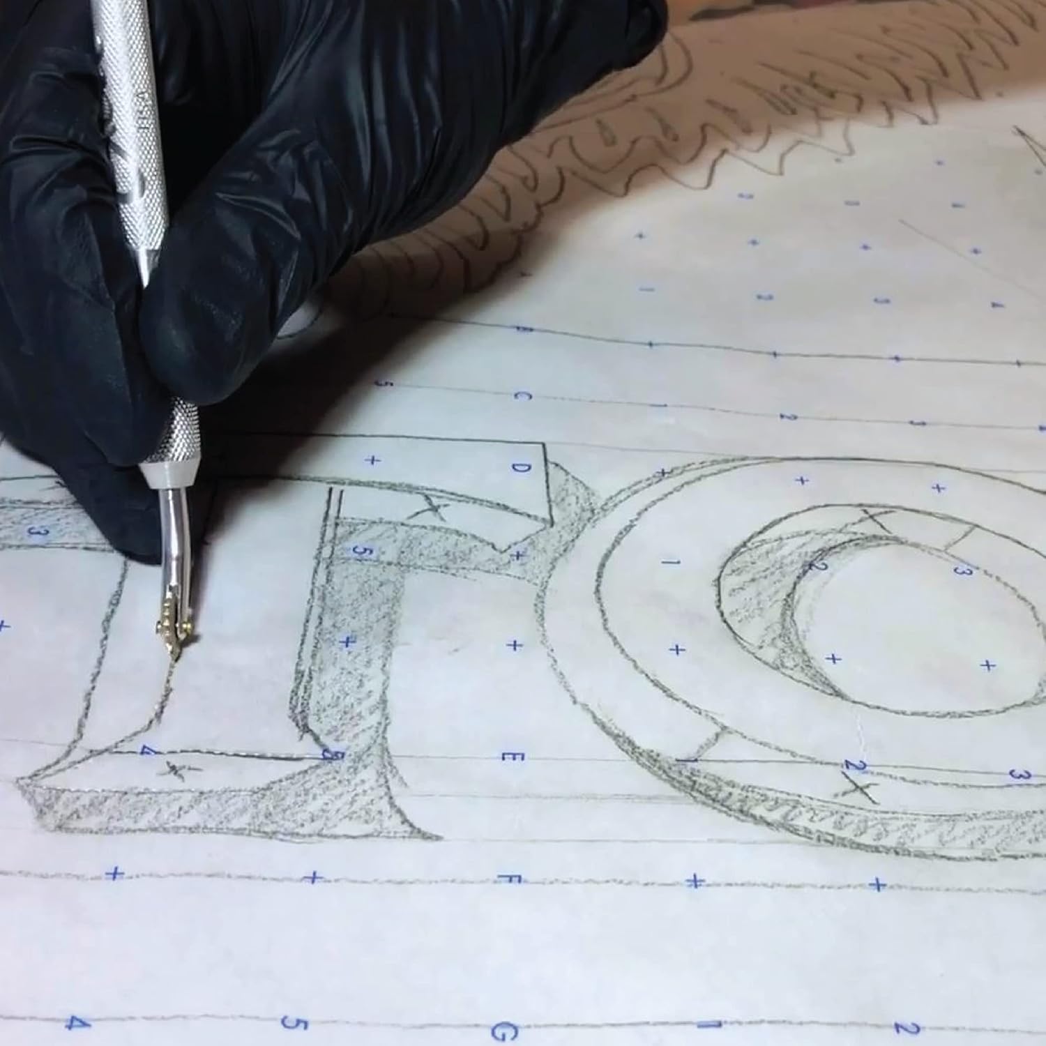 Person using pounce wheel to mark a pink sheet of paper on a cutting mat