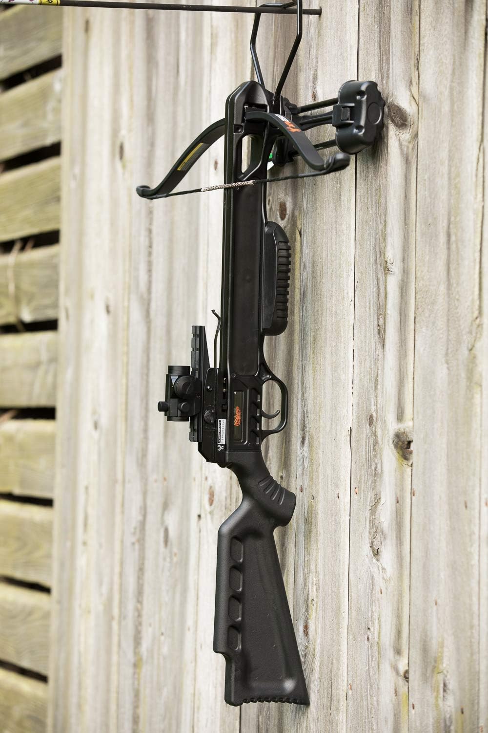 Wildgame Innovations XR250 Crossbow hanging vertically on a wooden fence.