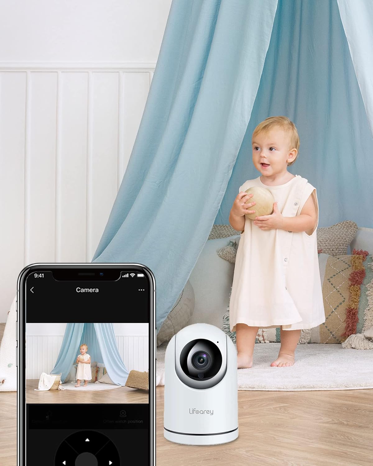 A baby in a room with the Lifoarey Q20 camera and a smartphone displaying the live camera feed.