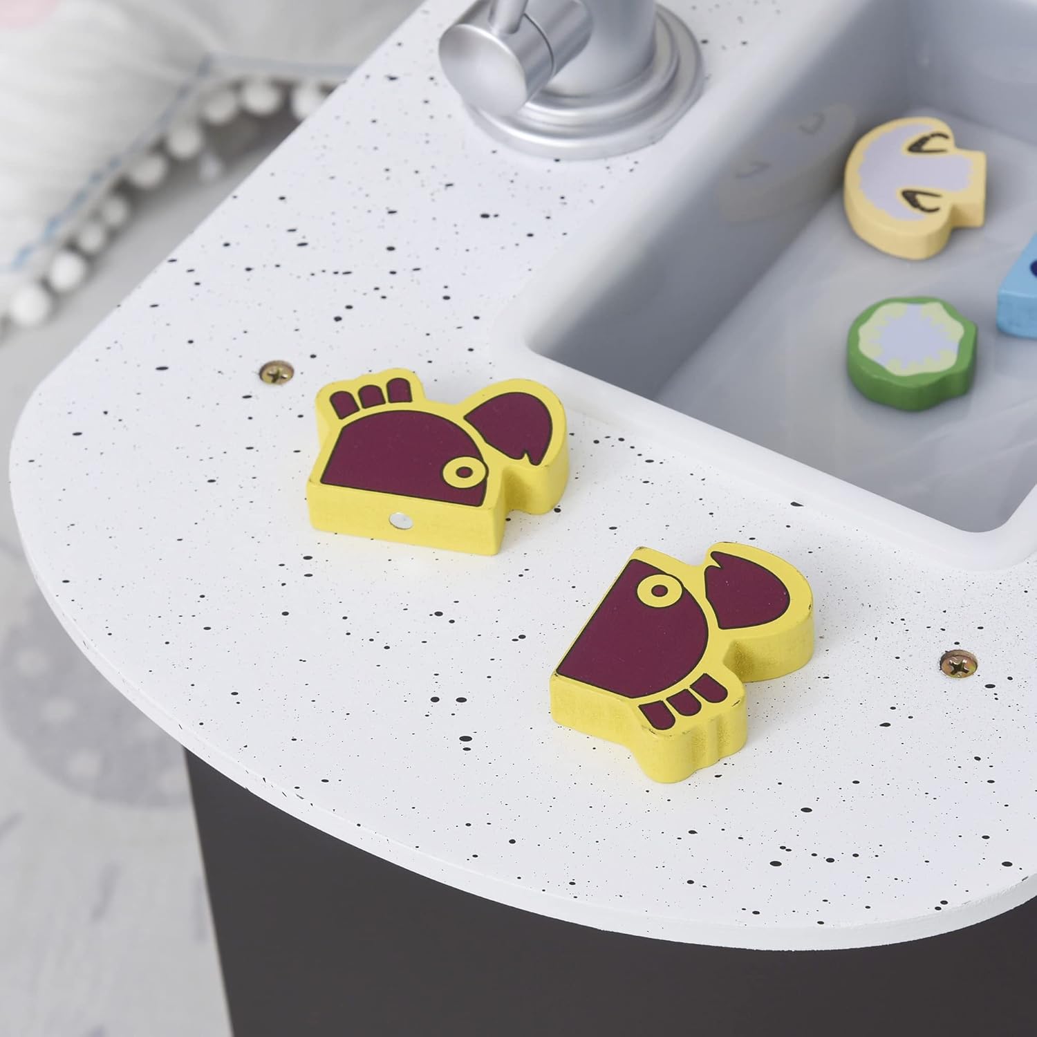 Close-up of the sink area of the Qaba Kids Kitchen Playset, showing the faucet, sink basin, and some toy food items on the countertop.
