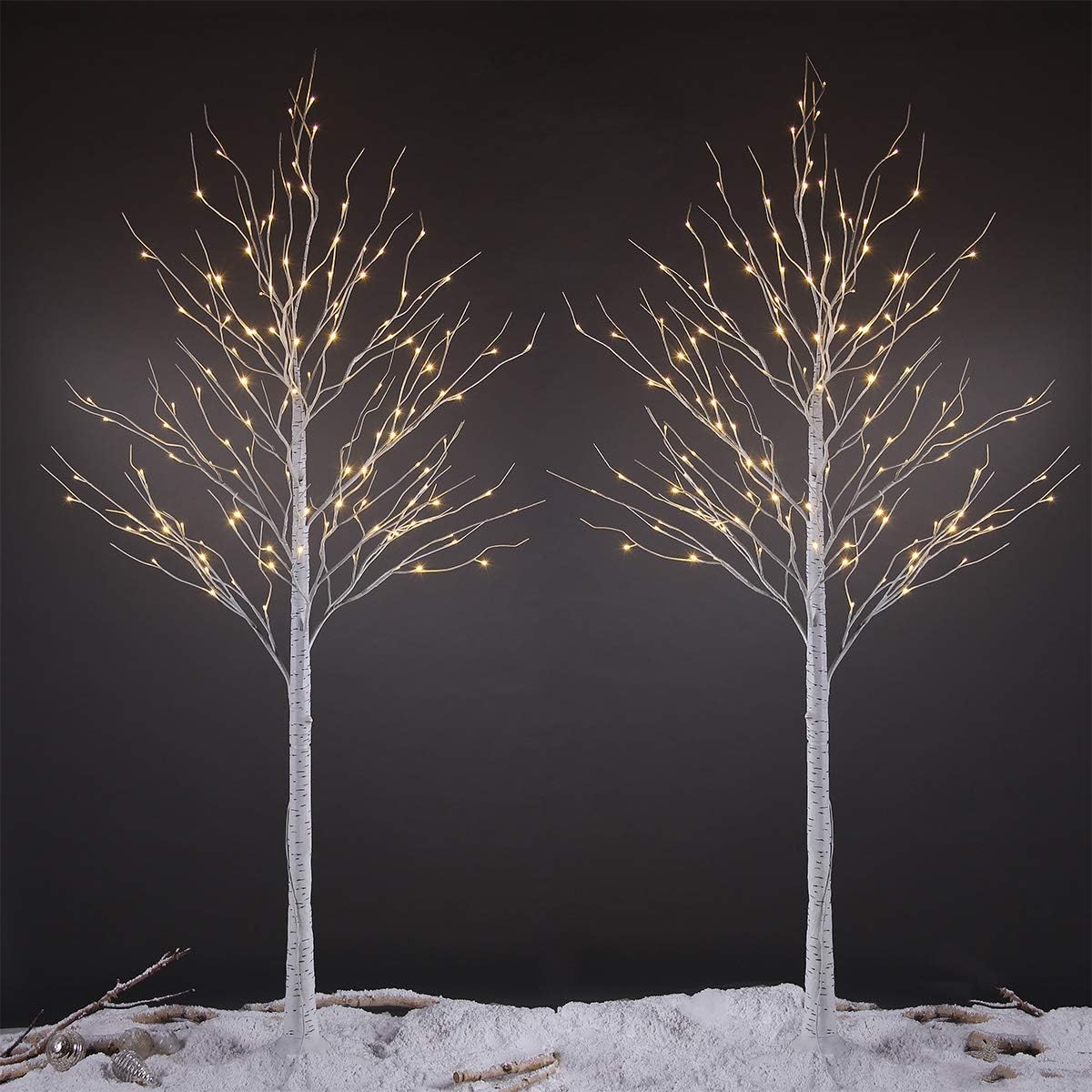 Two 8-foot LIGHTSHARE LED Birch Trees with warm white lights, standing in a dark setting.