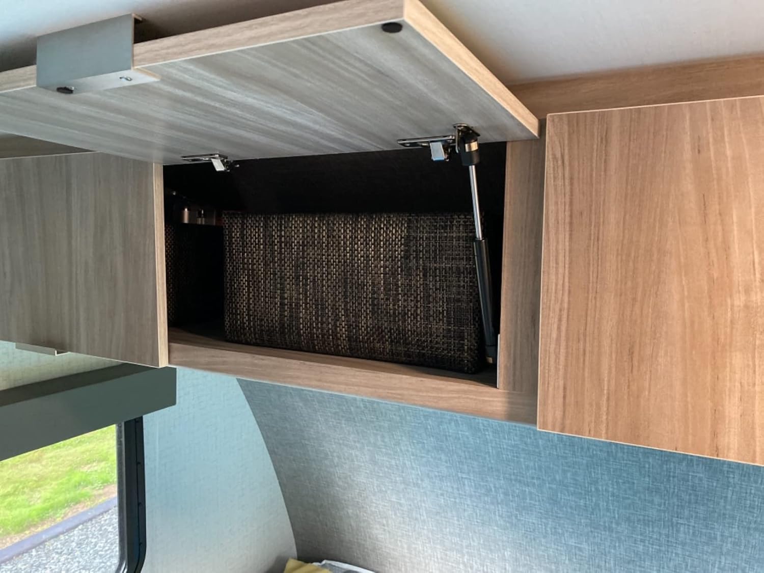 Gas strut installed in an overhead cabinet