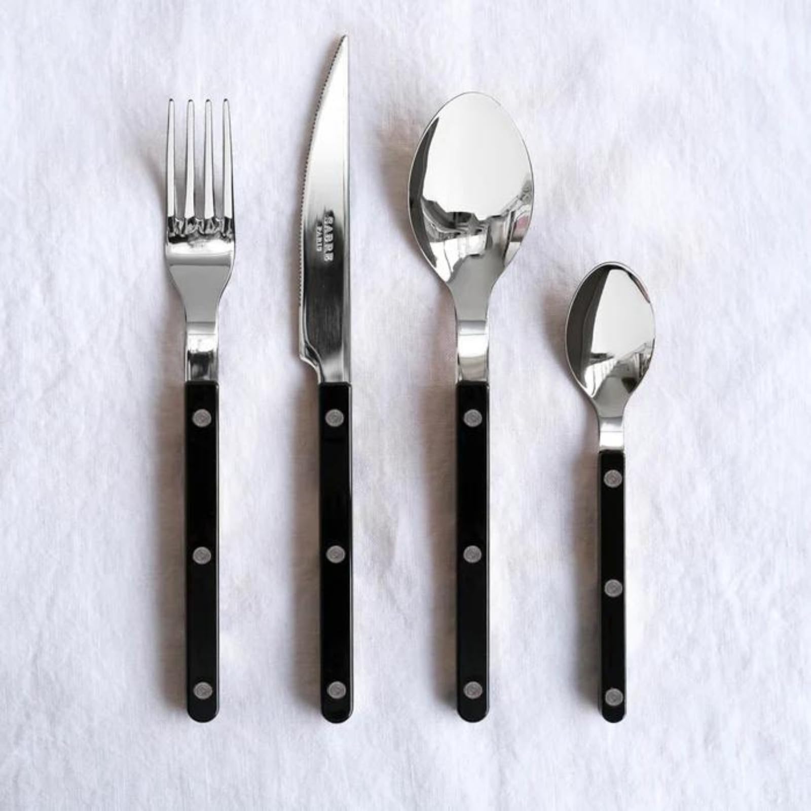 Sabre Paris | Ensemble de couverts de table 4 pièces 24cm Bistrot, couleur Noir et finition brillante. Comprend couteau, fourchette, cuillère à soupe et petite cuillère en Acier Inoxydable.