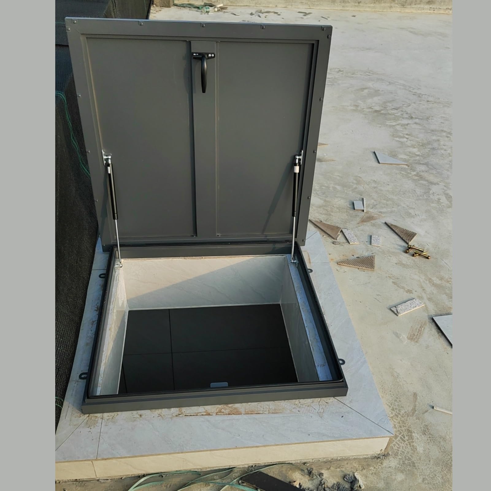 Puerta de acceso de ático con ventilación y reja antirrobo para pozo de sótano exterior