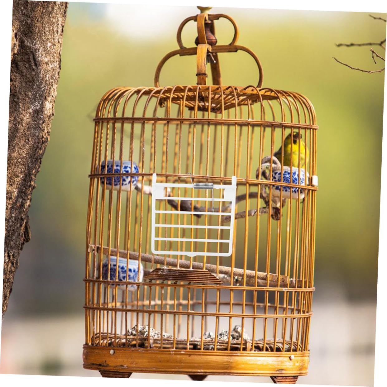 Bird cage spring door installed on a wooden bird cage