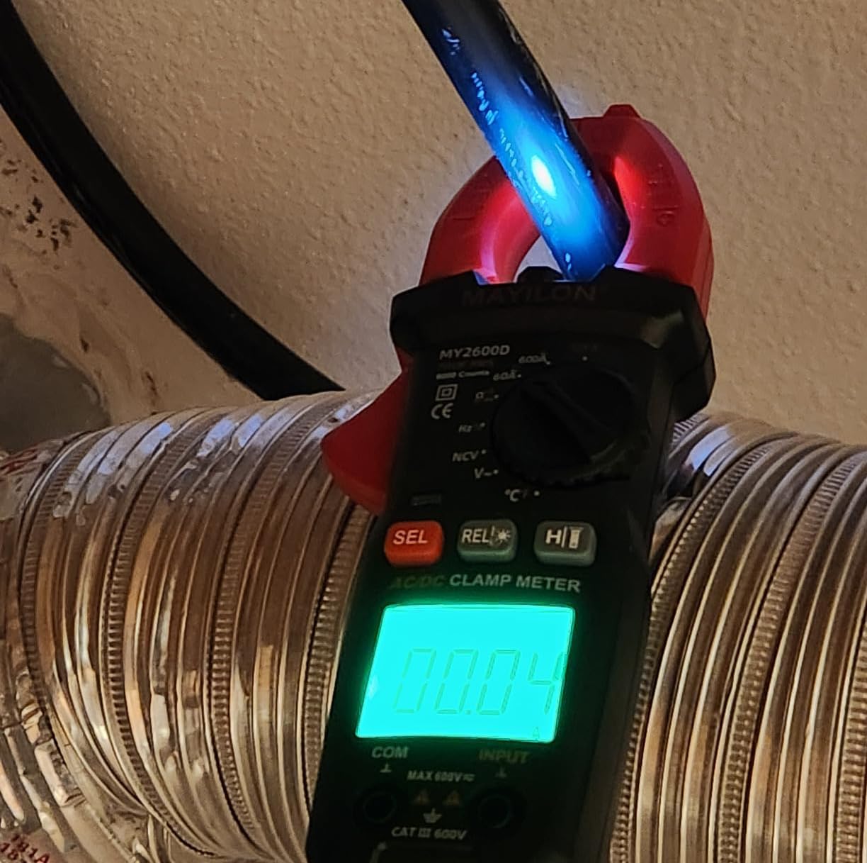 RQG MY2600D Digital Clamp Multimeter measuring current on a wire, showing a reading of 0.04.